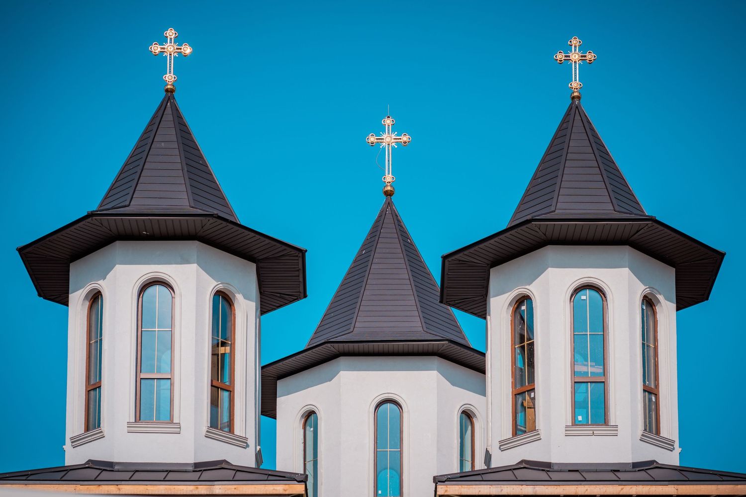Trei turle albe de biserica ortodoxa sub un cer senin, fotografie de arhitectura