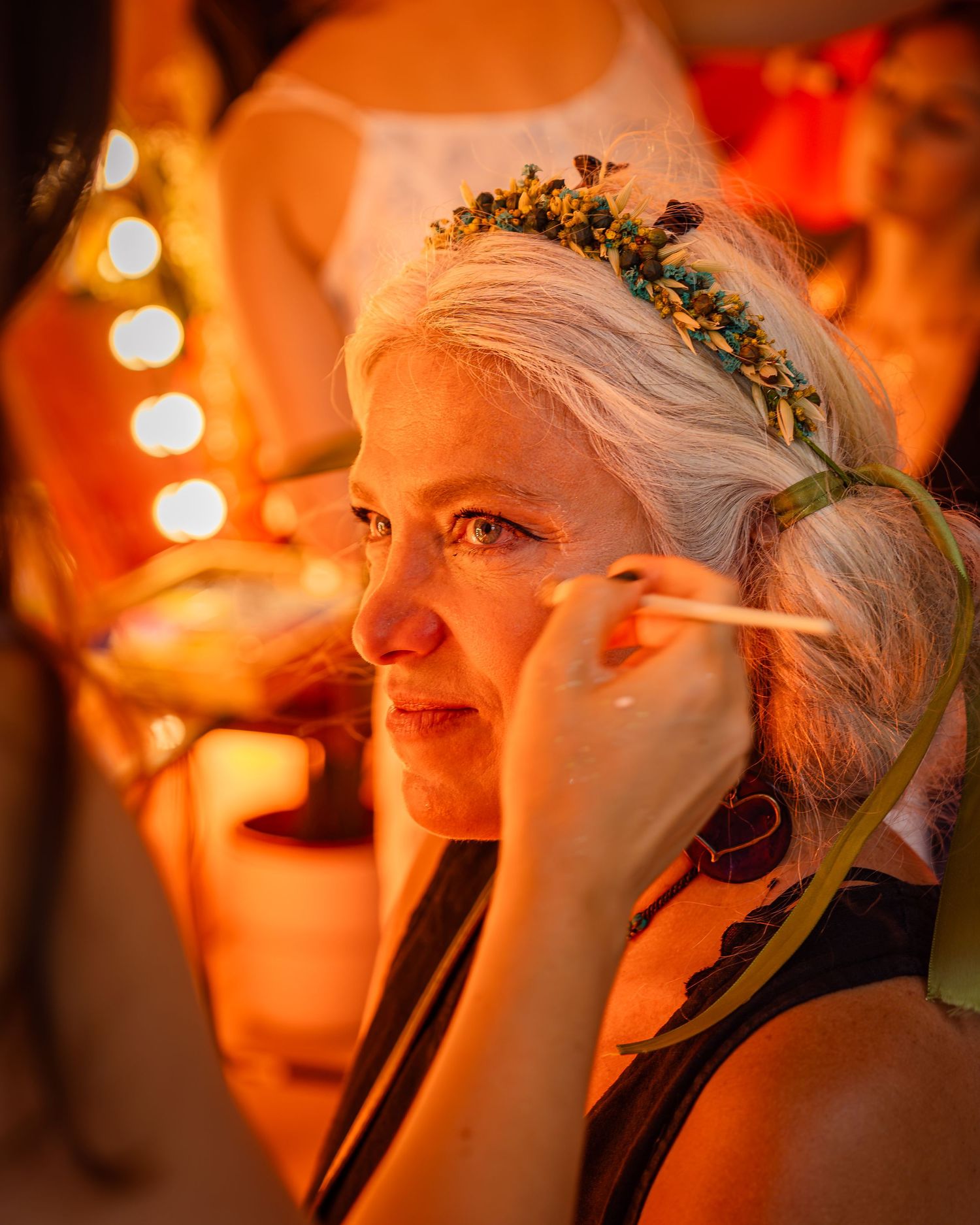 Femeie aplicandu-si machiaj la un stand de beauty din cadrul unui festival