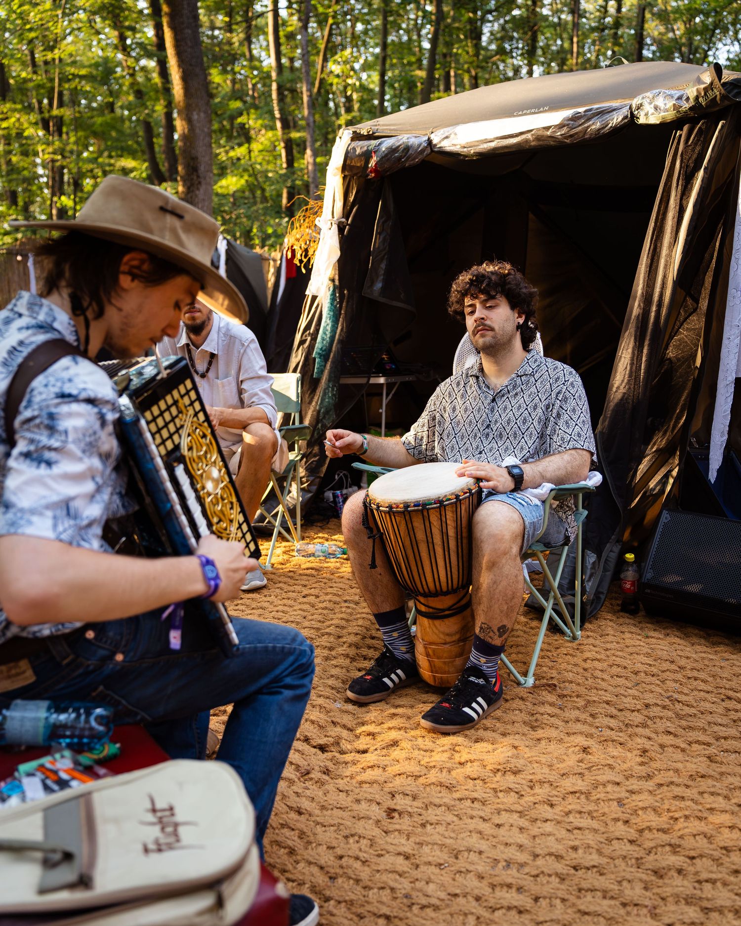 Doi muzicieni cantand la acordeon si djembe in zona de camping a festivalului