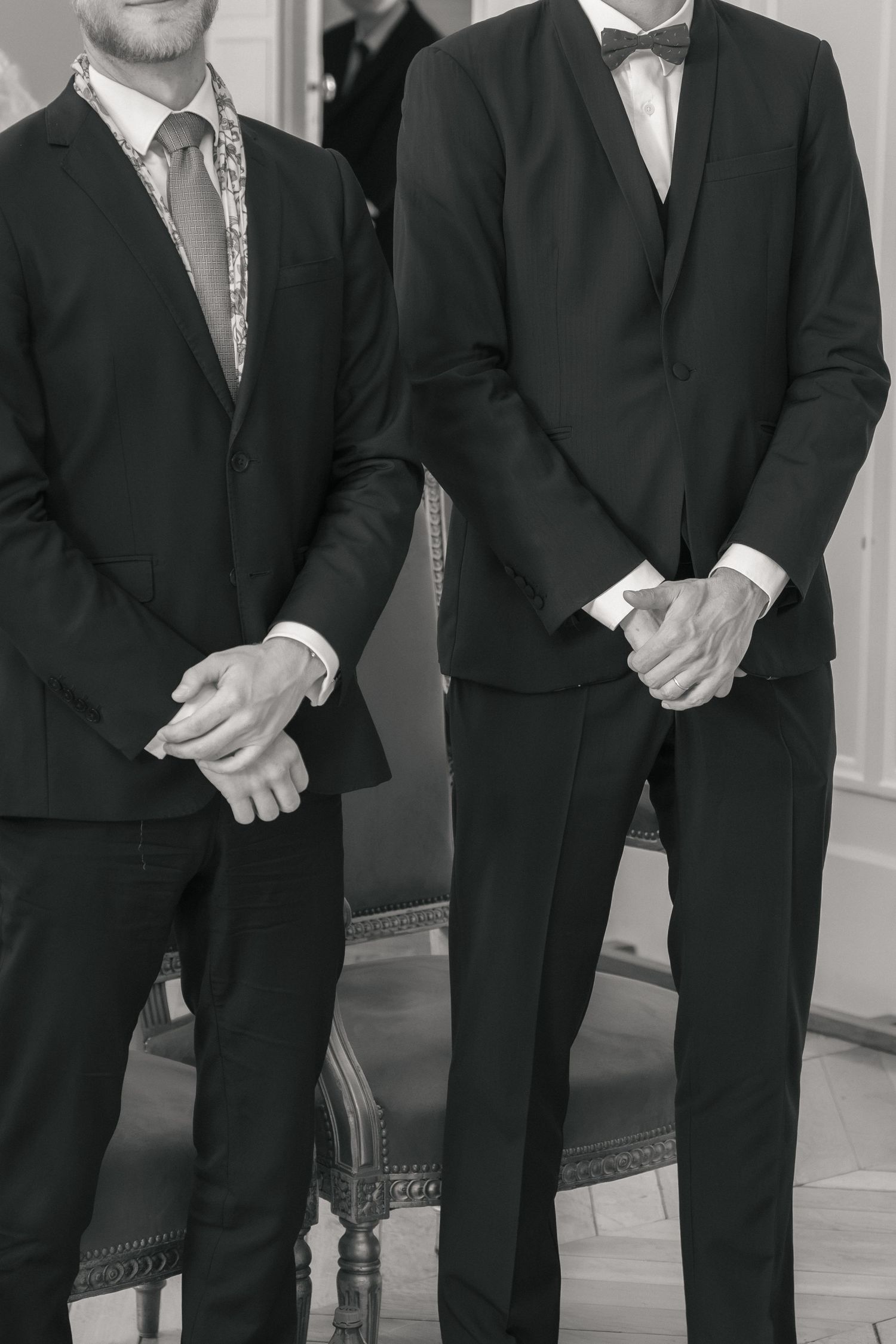 Témoins du mariage en costume pendant la cérémonie civile, photographiés en noir et blanc.