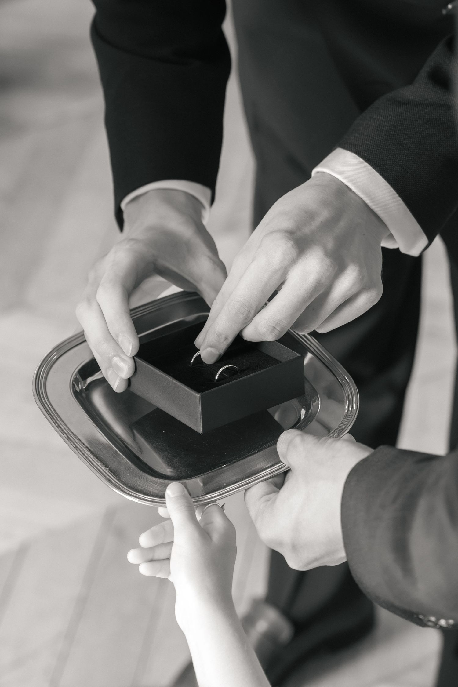 Échange des alliances pendant une cérémonie de mariage civil, photographié en noir et blanc.