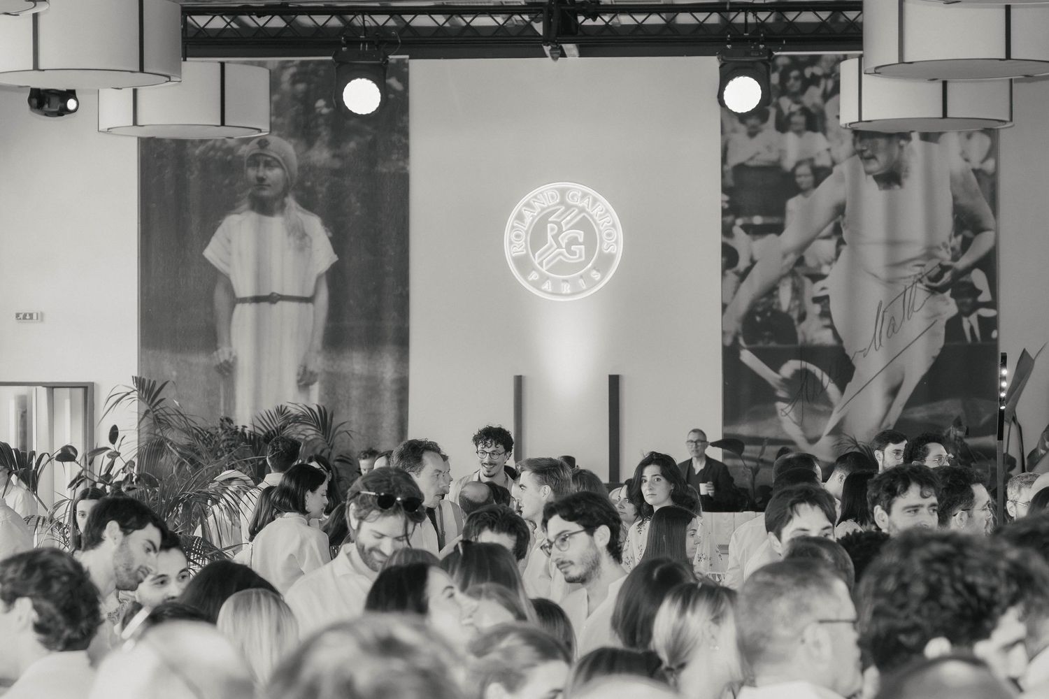 Invités réunis devant la scène lors d’une soirée d’entreprise à Paris, photographiés en noir et blanc.