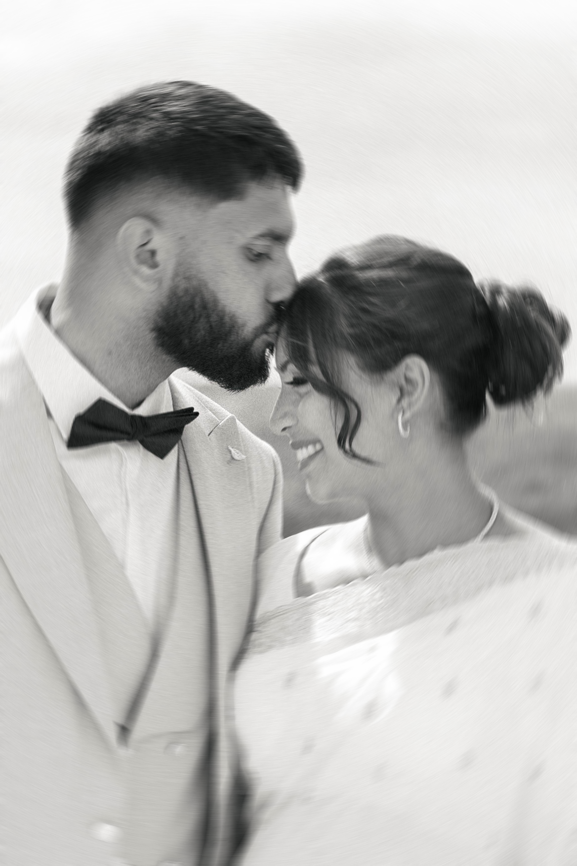 Portrait tendre et spontané d’un couple de mariés, réalisé en noir et blanc avec un léger flou de mouvement.