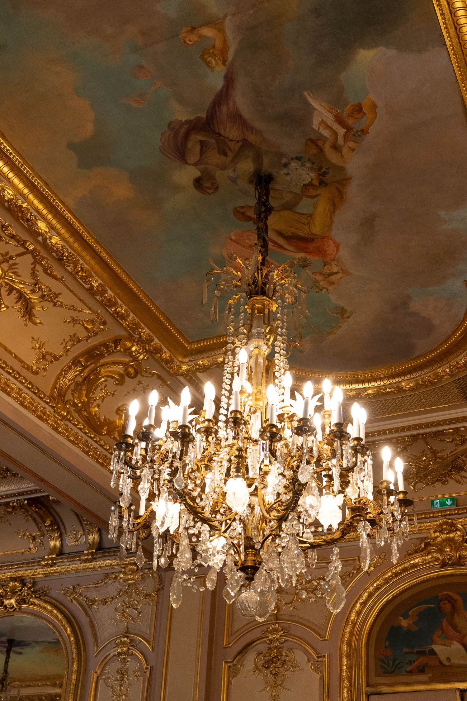 Lustre en cristal sous un plafond peint et doré dans la salle de mariage de la mairie du 8e arrondissement de Paris.