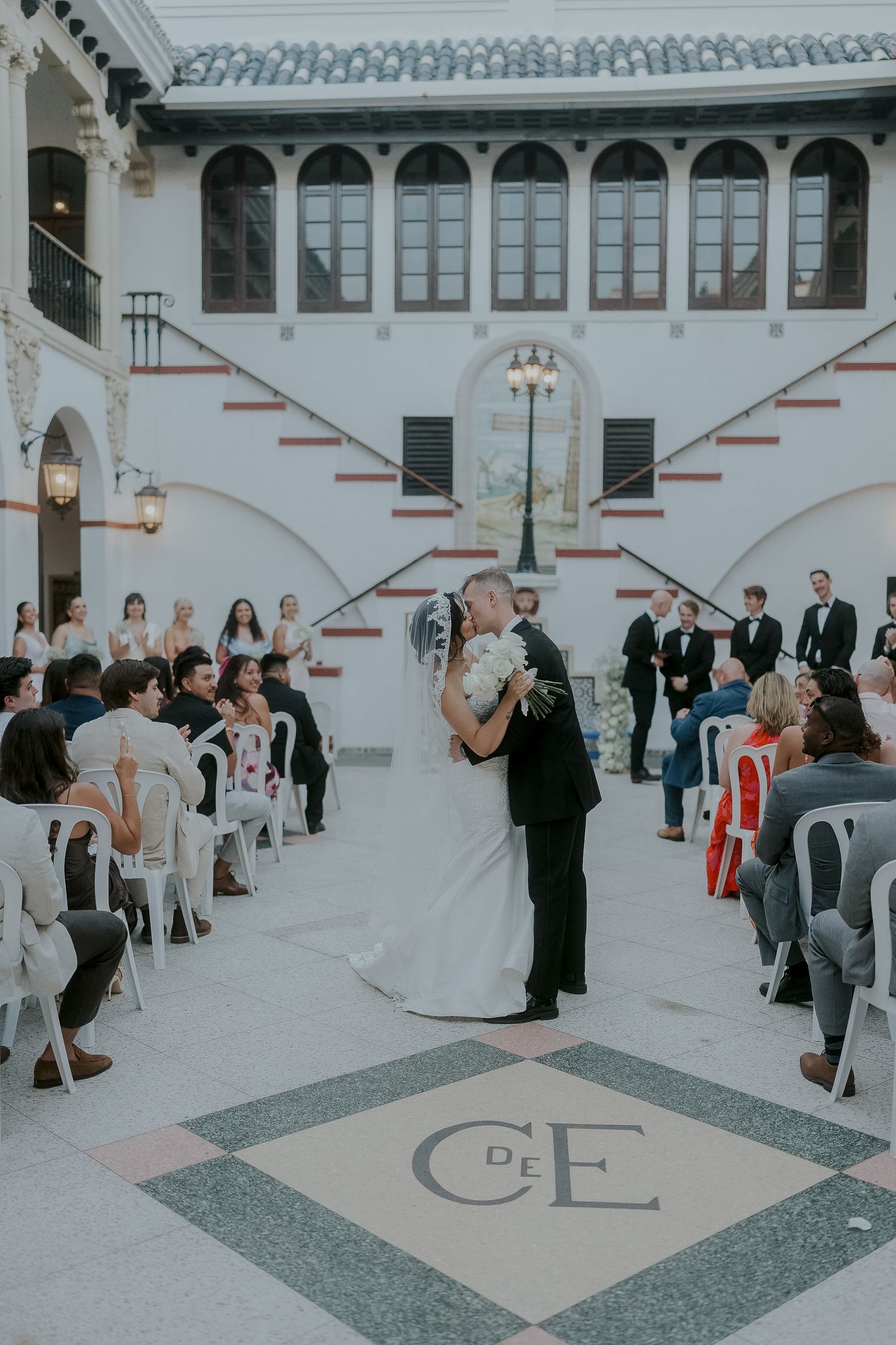 Bride and groom share first kiss at outdoor wedding ceremony at Casa de España, San Juan, Puerto Rico.