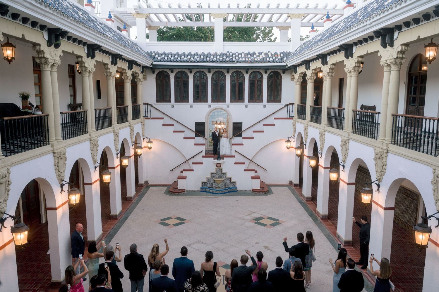 Elegant wedding ceremony in a stunning Moorish-style courtyard with arched galleries and ornate architecture.