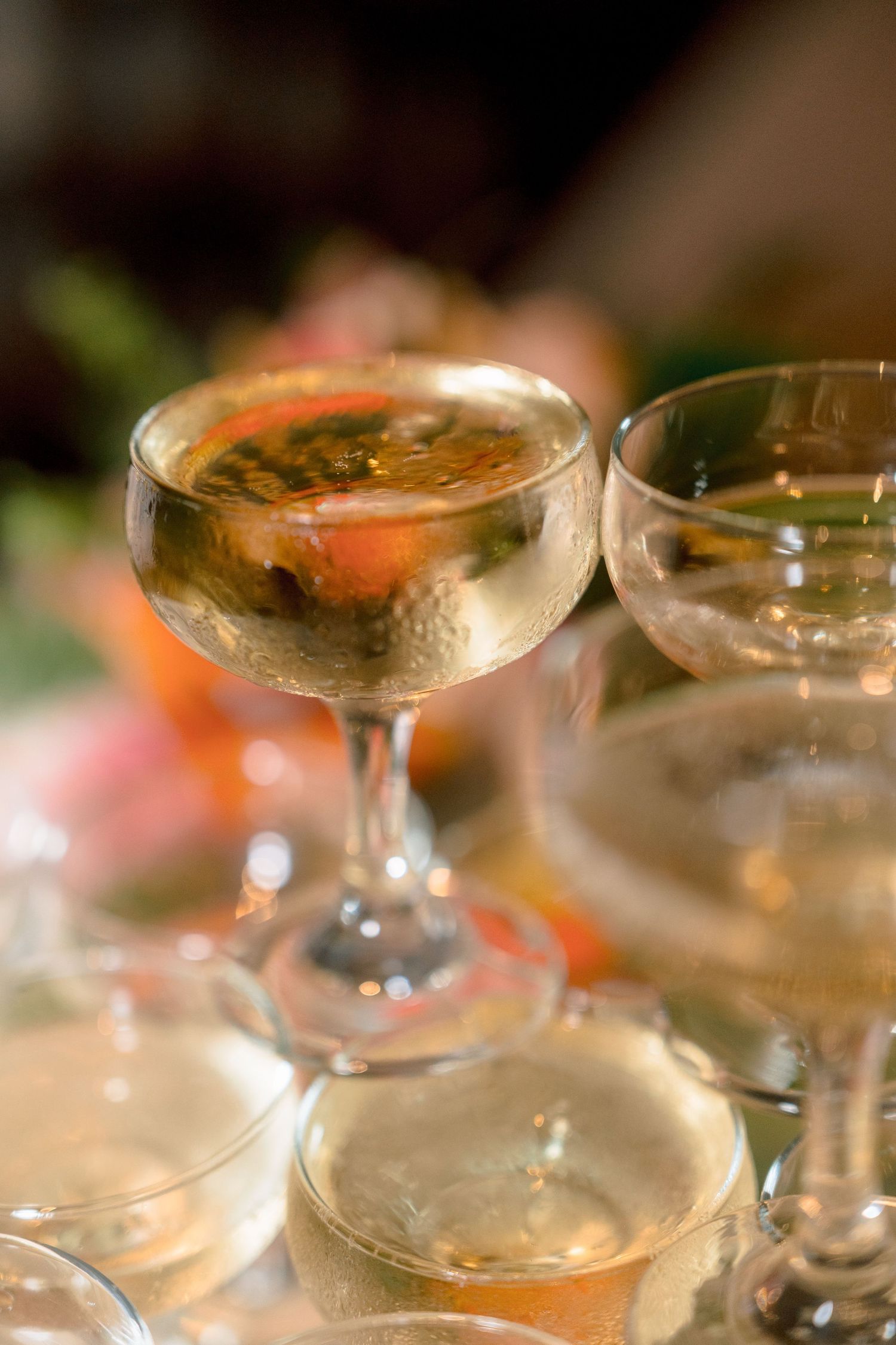 Close-up of champagne coupe glass filled with sparkling wine on a wedding reception table.