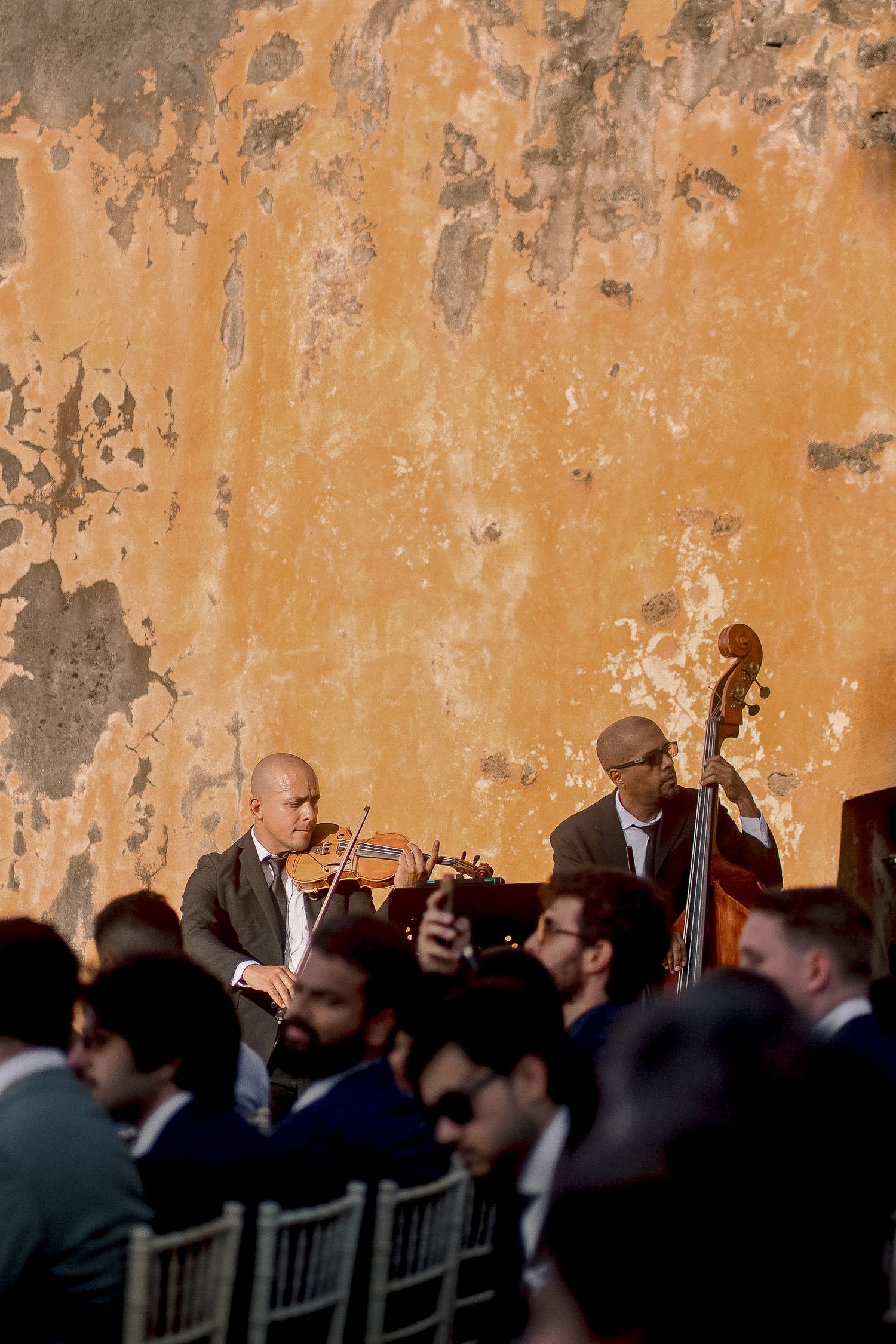 Live string musicians performing violin and double bass at an elegant wedding.