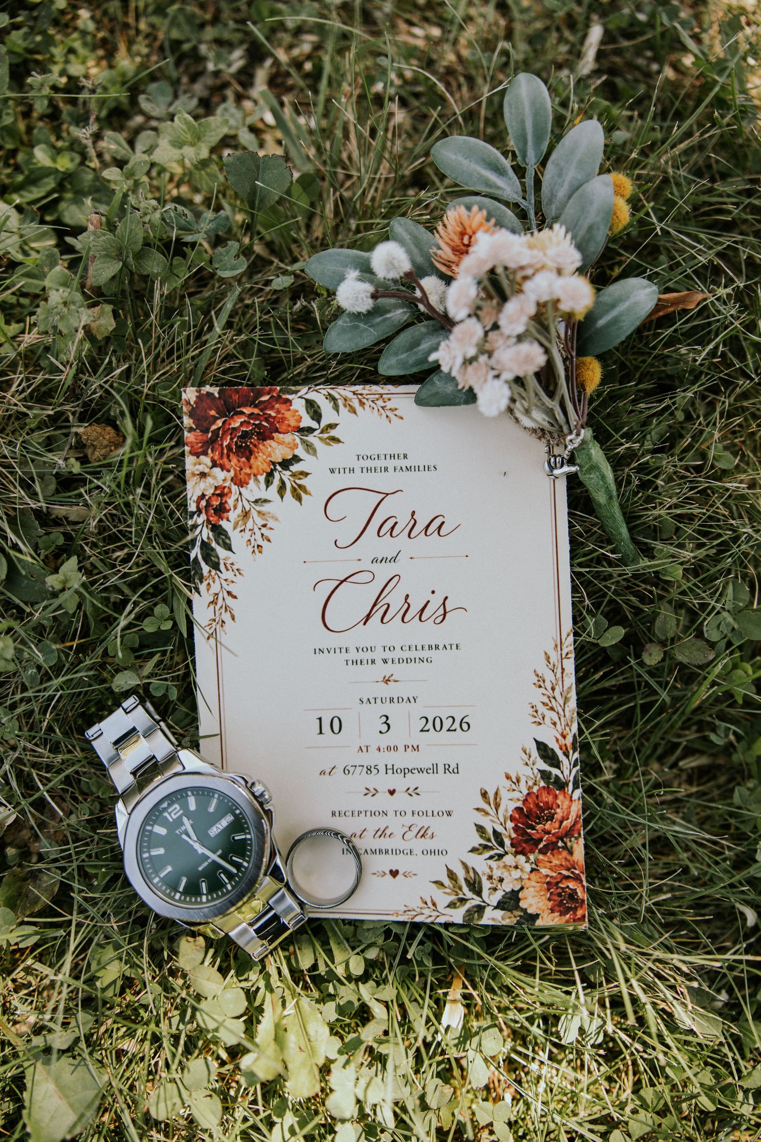 Elegant fall wedding invitation for Tara and Chris dated October 3, 2026, displayed with a watch, ring, and floral bouquet on grass.