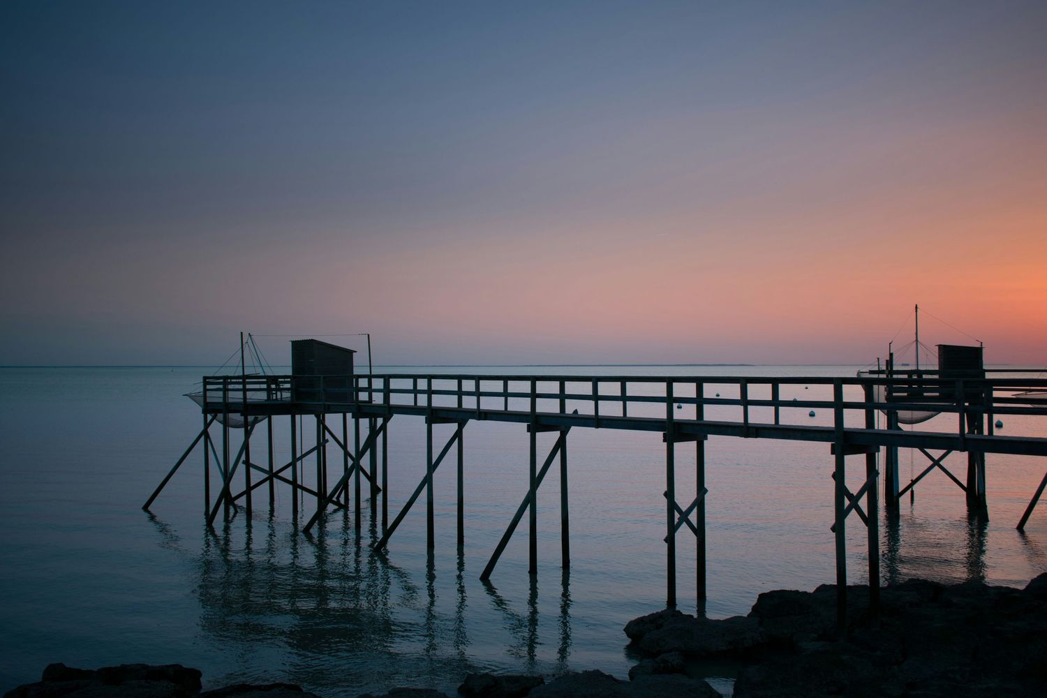 Carrelets de Fouras se découpant sur un ciel de coucher de soleil au-dessus de l'océan - Photographie de Simon Pallard pour Unsplash
