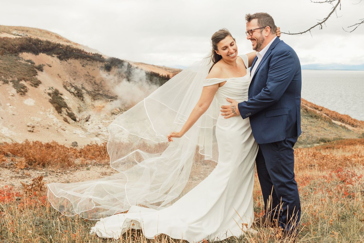 Couple in Yellowstone National Park having their post wedding celebration bridal session on a geyser.