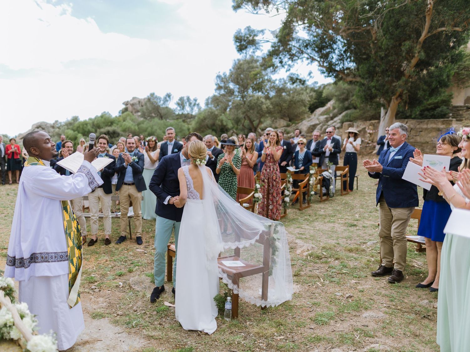 Cérémonie de mariage en plein air avec les mariés à l'autel, les invités applaudissant à la trinité de Bonifacio en corse