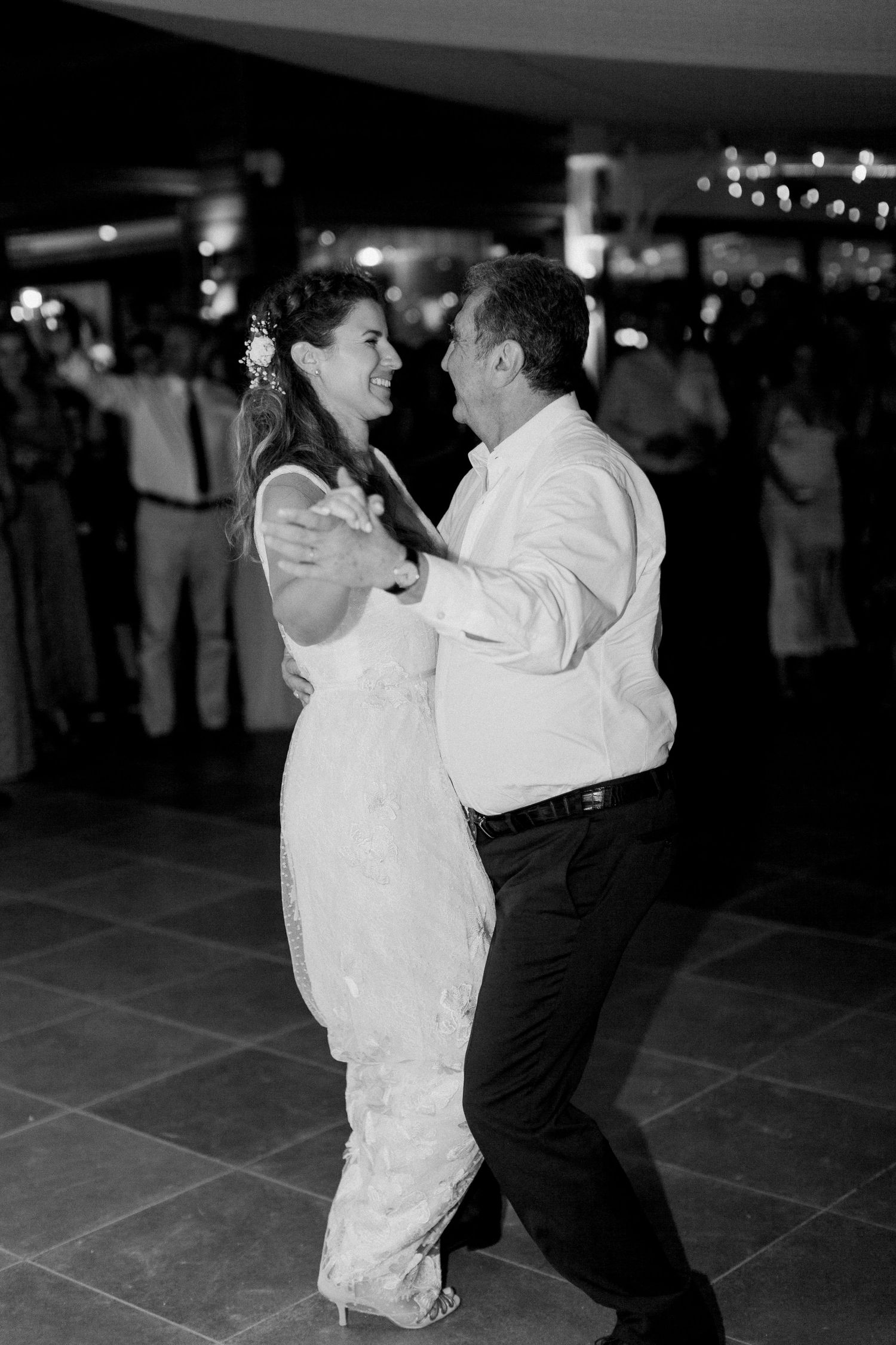 Photo en noir et blanc d'une mariée et d'un marié partageant leur première danse lors d'une réception de mariage.