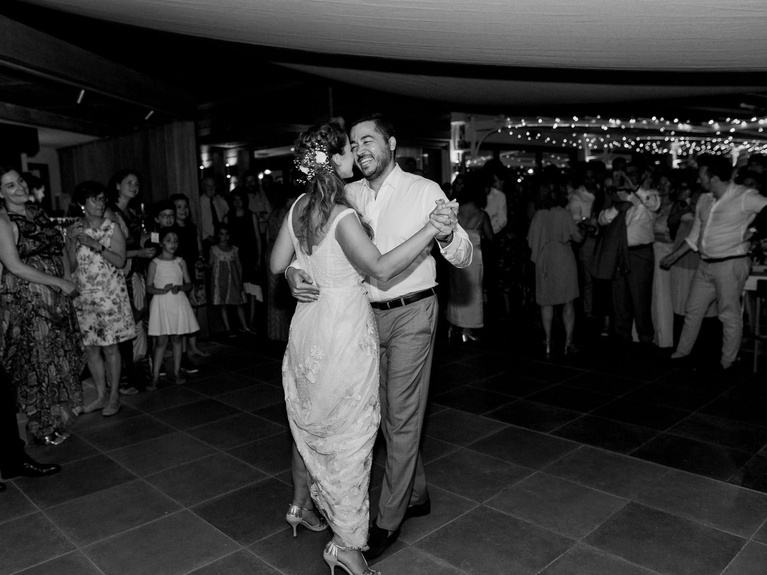 Les mariés partagent leur première danse entourés de leurs invités lors d'une élégante réception de mariage.