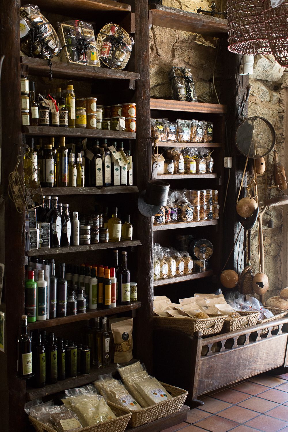 Des étagères en bois rustiques regorgent d'huiles d'olive, de vins, d'épices et de produits alimentaires gastronomiques