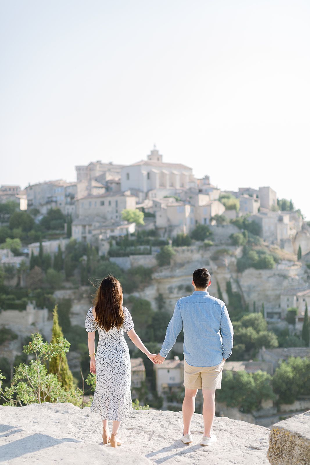 Un couple se tient la main en admirant le pittoresque village perché de Gordes, dans le sud de la France.