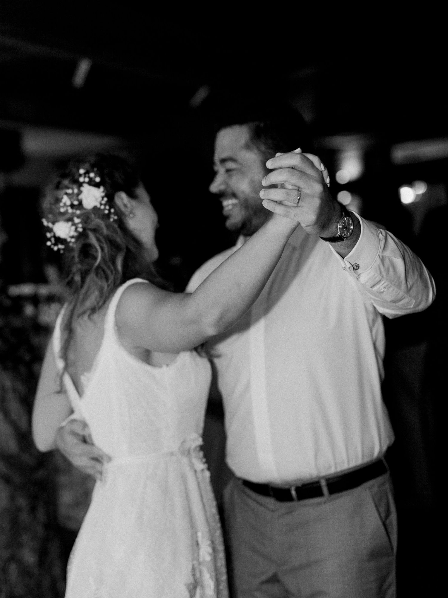 Photo en noir et blanc d'une mariée et d'un marié partageant leur première danse lors d'une réception de mariage.