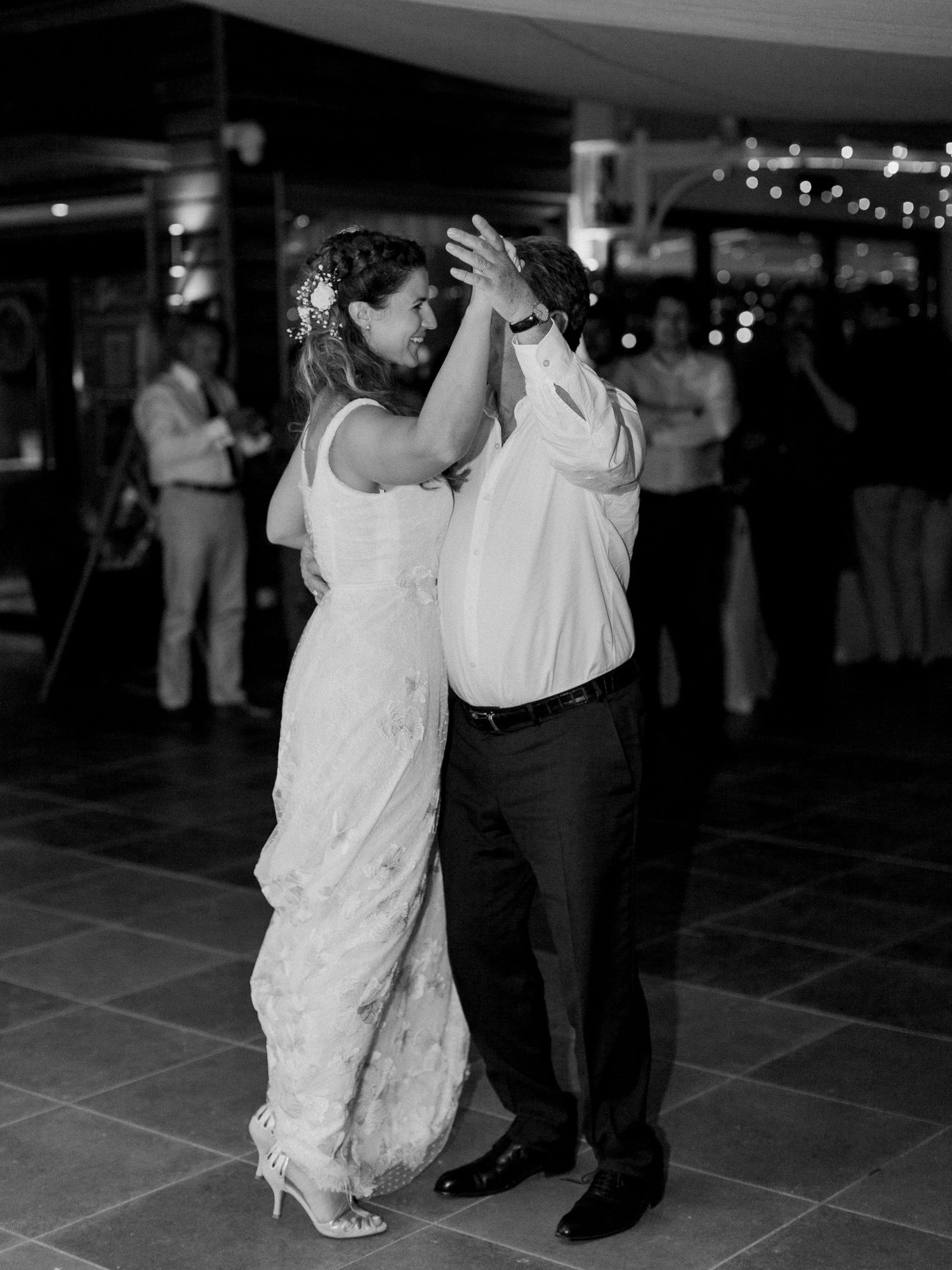 Photo en noir et blanc des mariés partageant leur première danse lors de la réception de mariage.