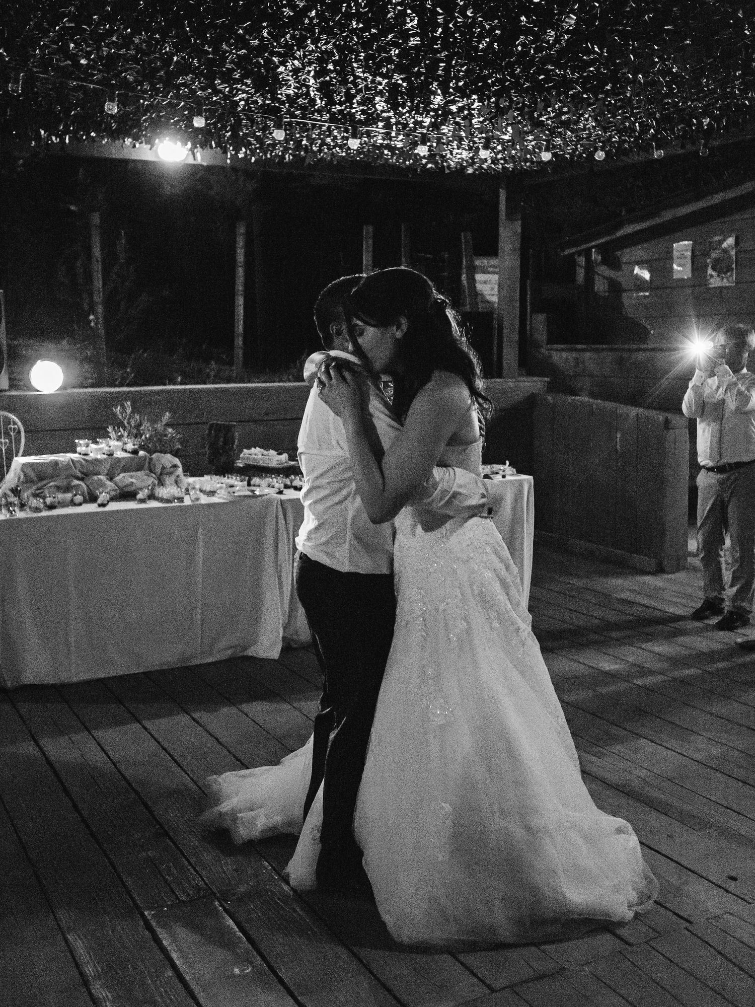 Photo en noir et blanc d'une mariée et d'un marié partageant leur première danse lors d'une réception de mariage en plein air à Ajaccio