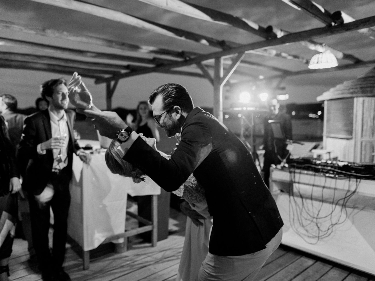 Photo en noir et blanc d'hommes dansant avec énergie lors d'une réception de mariage maora Beach à Bonifacio corse