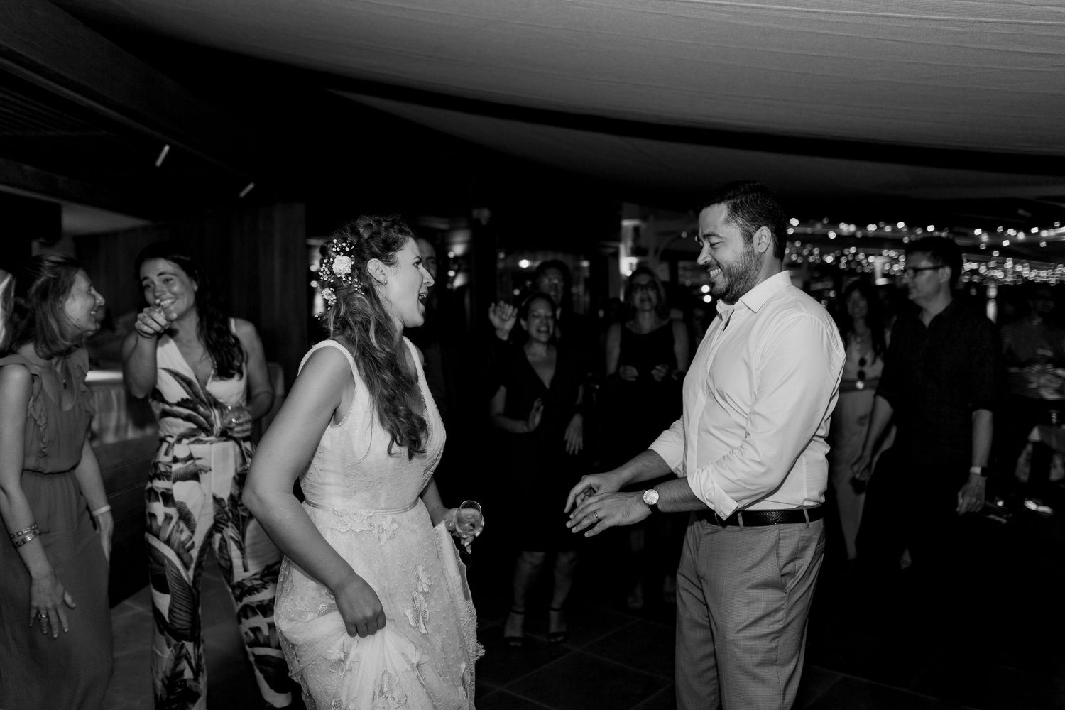 Photo en noir et blanc des mariés partageant une première danse joyeuse lors de leur réception de mariage a l'hôtel le week end à ajaccio