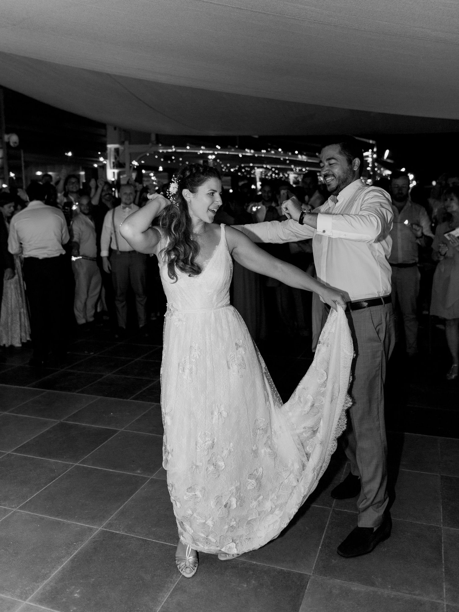 Les mariés partagent leur première danse lors de la réception de mariage sur une photo en noir et blanc.