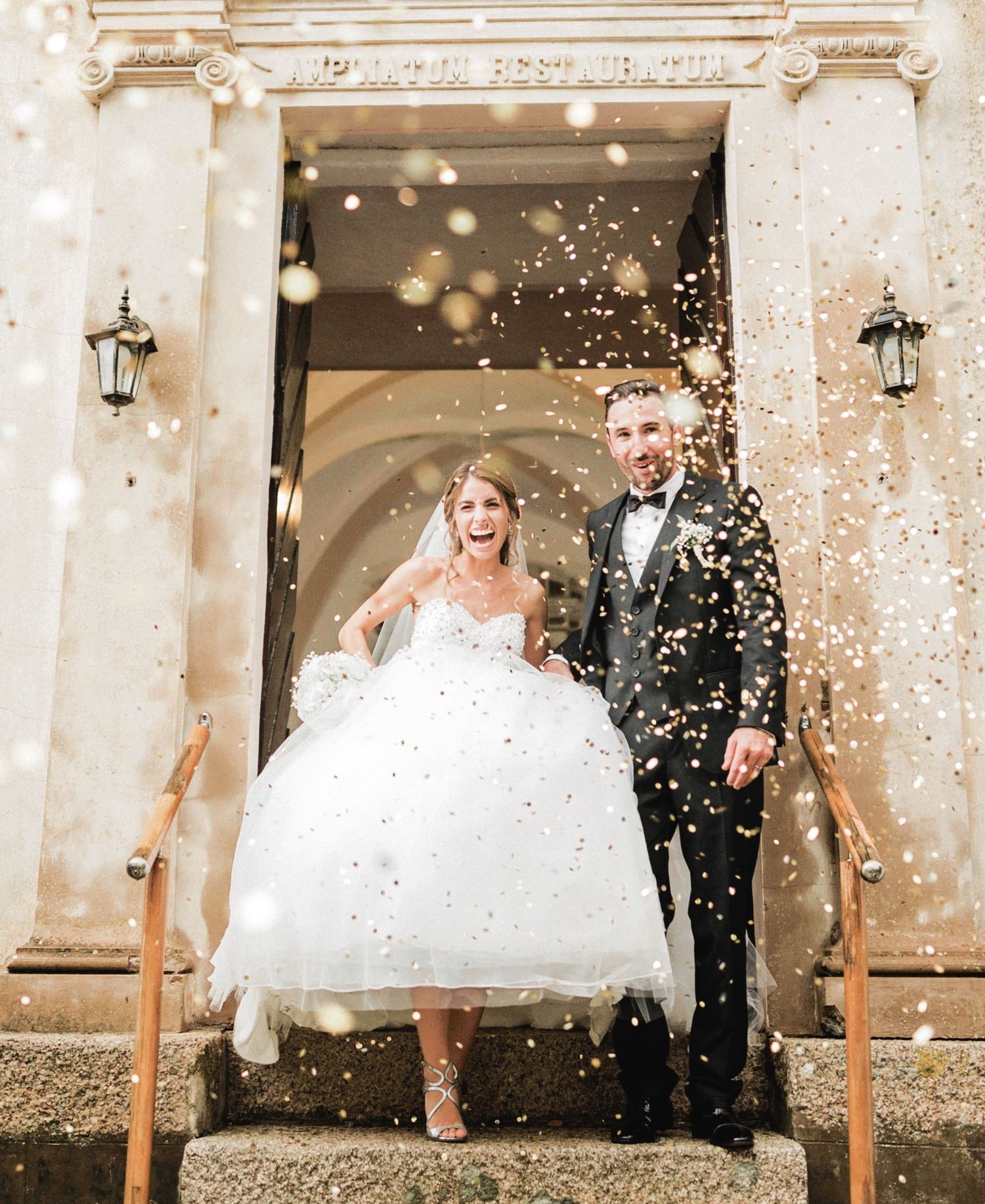 Sur cette photo de joyeuse célébration de mariage, les mariés sortent de l'église sous une pluie de confettis dorés à Bonifacio