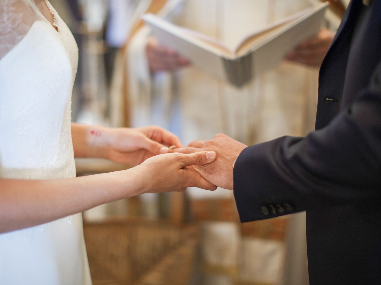 Bride and groom exchanging wedding rings during a church ceremony, symbolizing their eternal commitment.