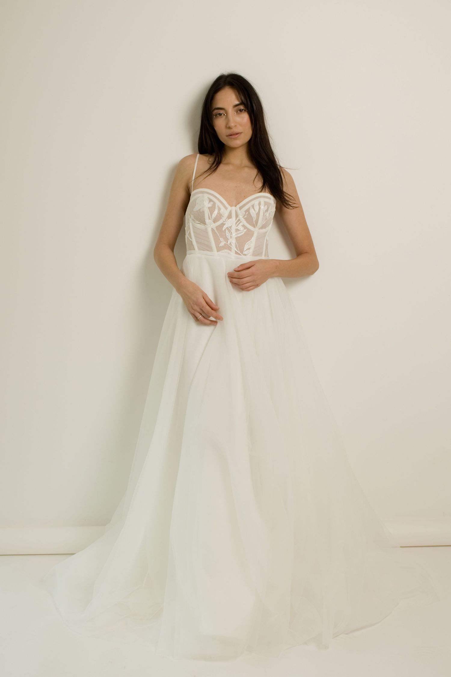 Élégante robe de mariée coupe trapèze avec corsage en dentelle, fines bretelles et jupe fluide en tulle blanc.