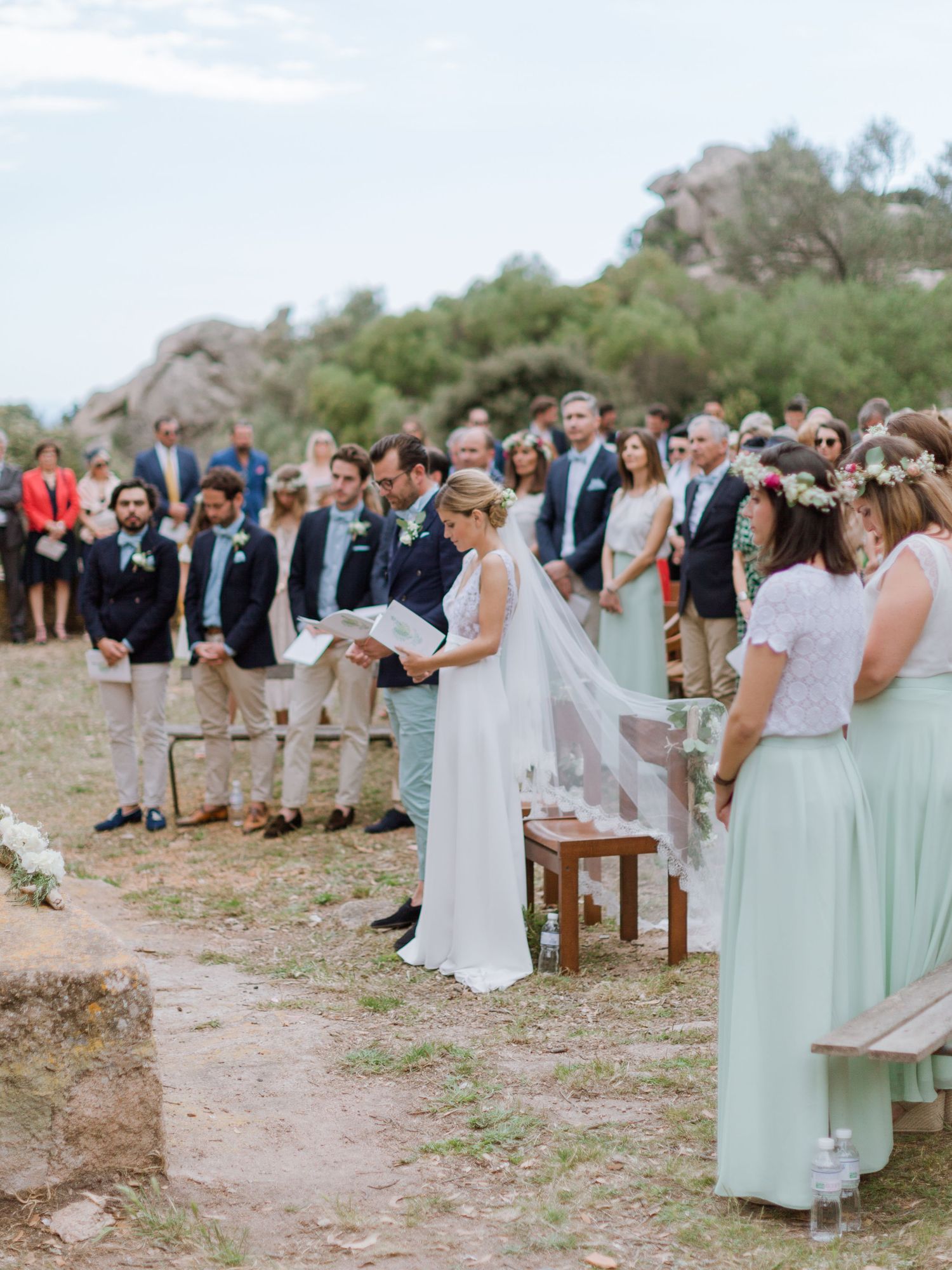 La mariée lit ses vœux lors d'une cérémonie de mariage en plein air, les demoiselles d'honneur portant des robes menthe