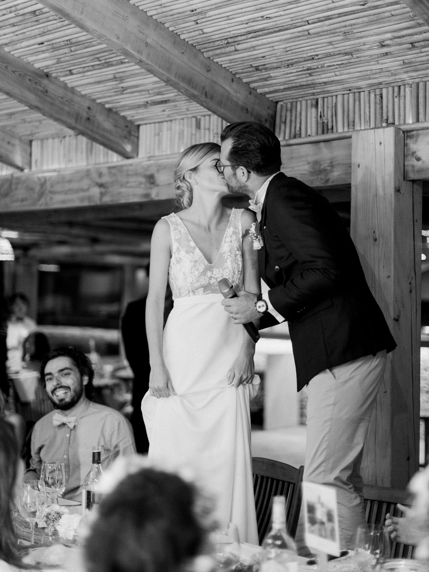 Photo en noir et blanc d'une mariée et d'un marié s'embrassant lors de leur réception de mariage,  au maora Beach en corse