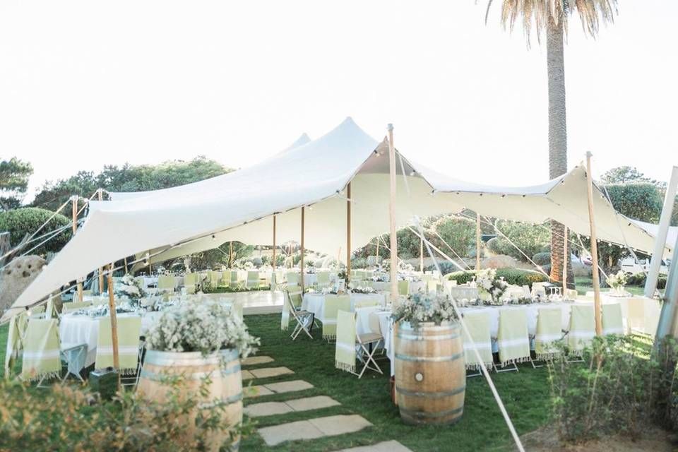 Réception de mariage élégante en plein air sous une tente blanche avec des tables rondes, au restaurant le trois deux porto-vecchio.