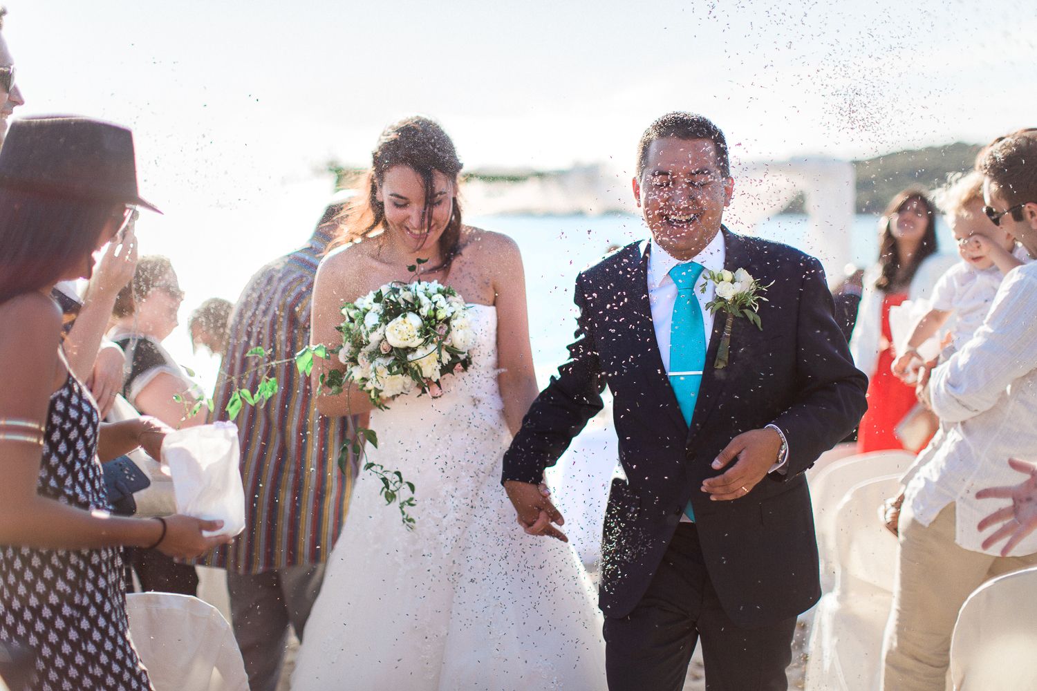 Les mariés descendent l'allée sous une pluie de confettis lors d'une cérémonie de mariage en plein air sur la plage. En Corse à Ajaccio