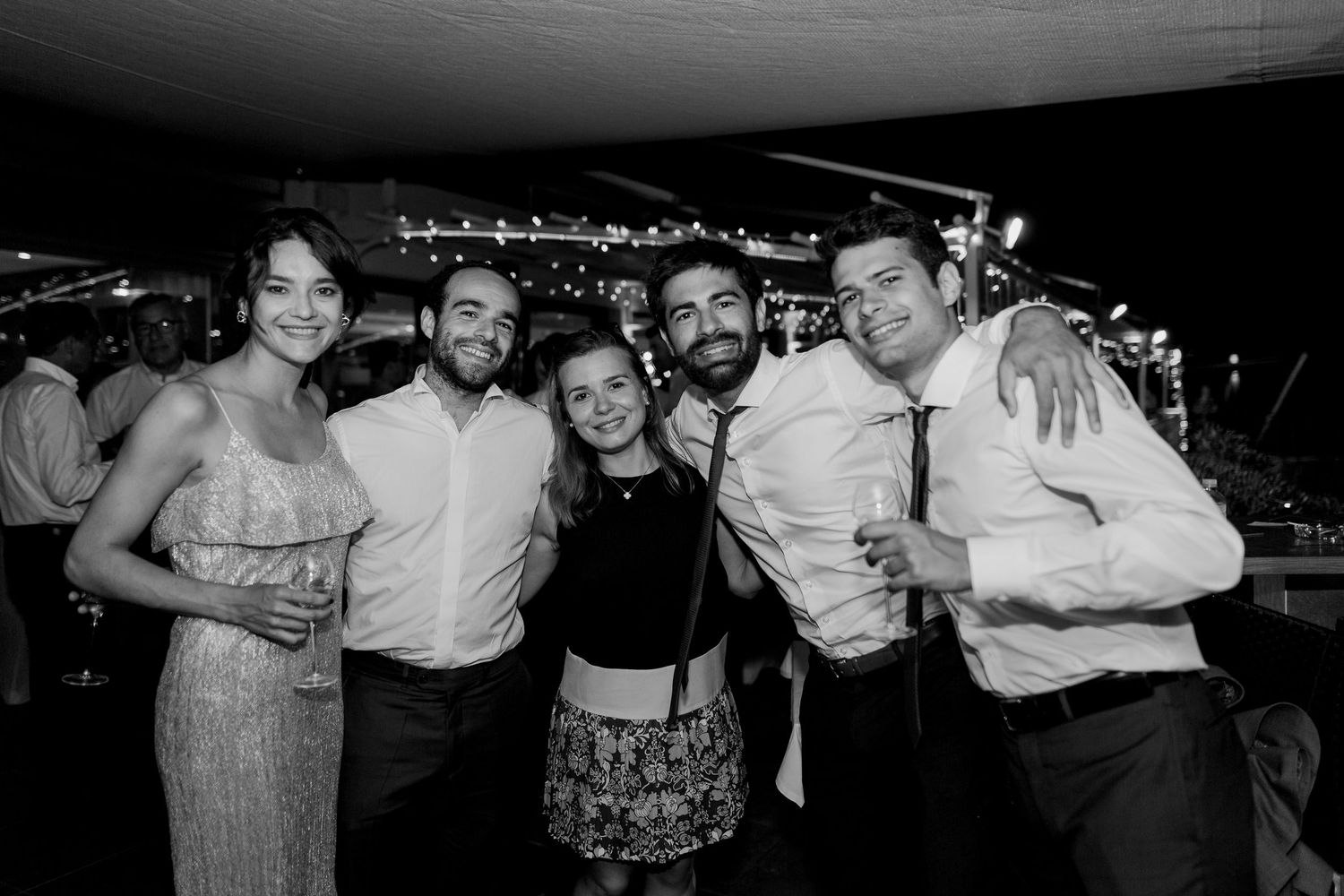 Photo en noir et blanc de cinq amis posant ensemble lors d'une réception de mariage à l'hotel le weekend à Ajaccio