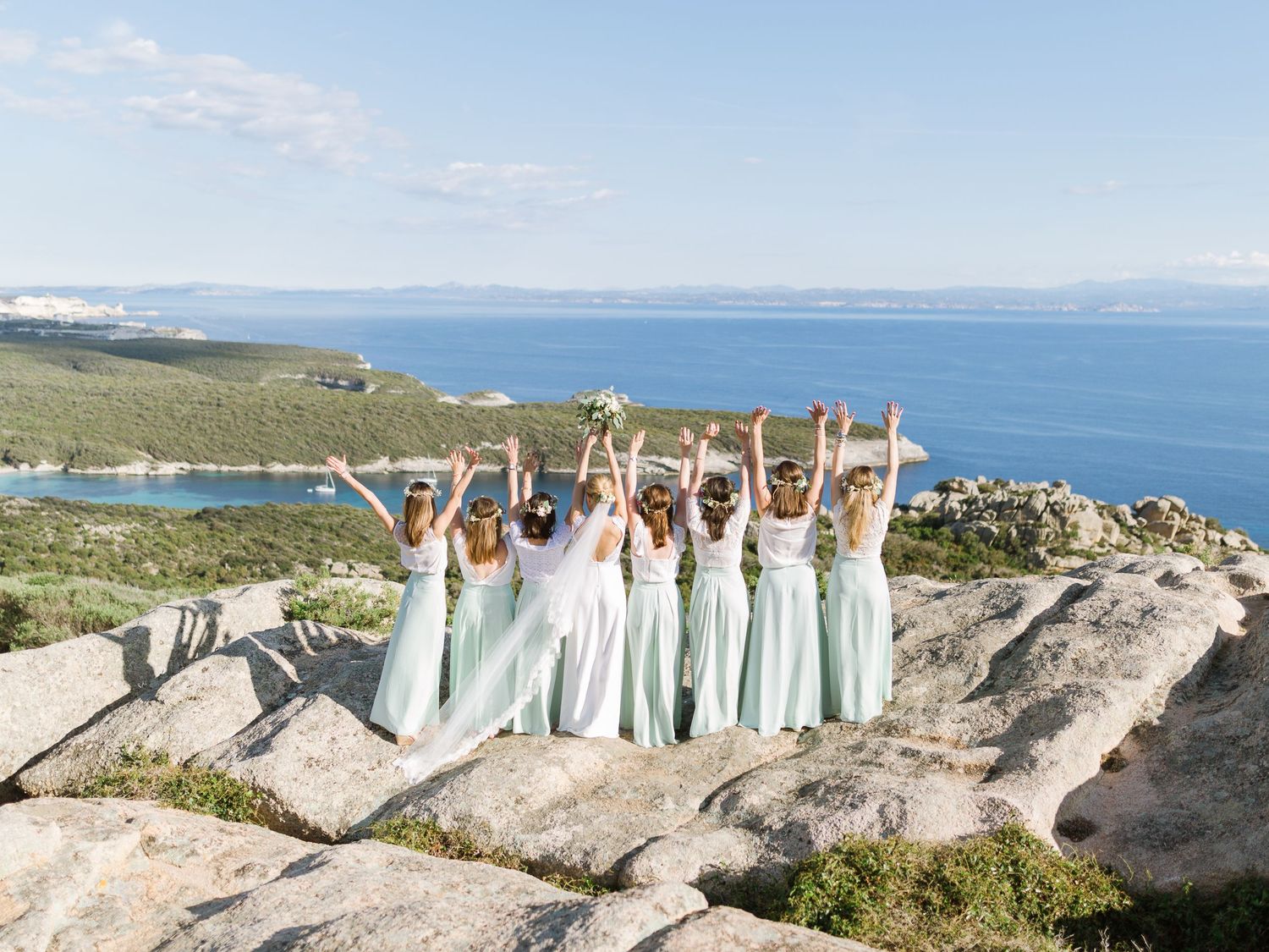 Des demoiselles d'honneur en robes vert menthe célèbrent l'événement sur une colline rocheuse offrant une vue imprenable sur Bonifacio.