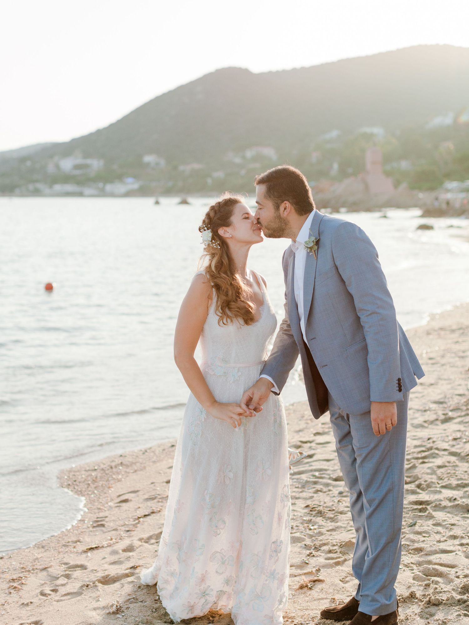 Jeunes mariés échangeant un baiser romantique sur la plage au coucher du soleil à l'hôtel le week end à Ajaccio