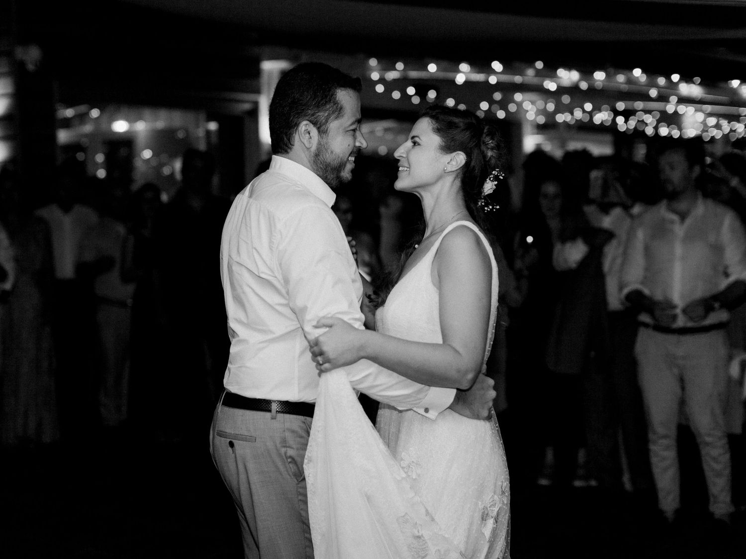 Photo en noir et blanc d'une mariée et d'un marié partageant leur première danse lors d'une réception de mariage.