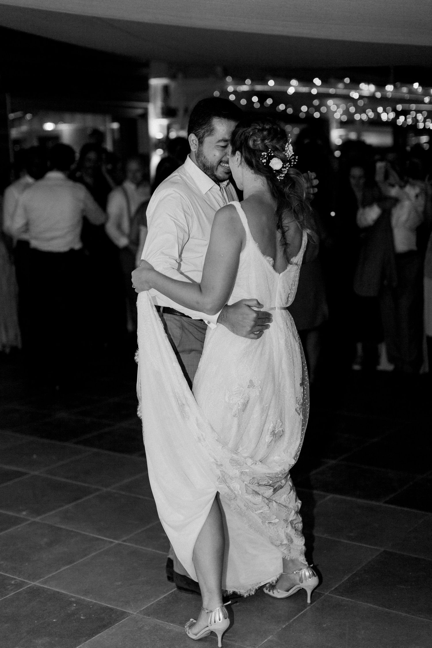 Photo en noir et blanc d'une mariée et d'un marié partageant leur première danse lors d'une réception de mariage.