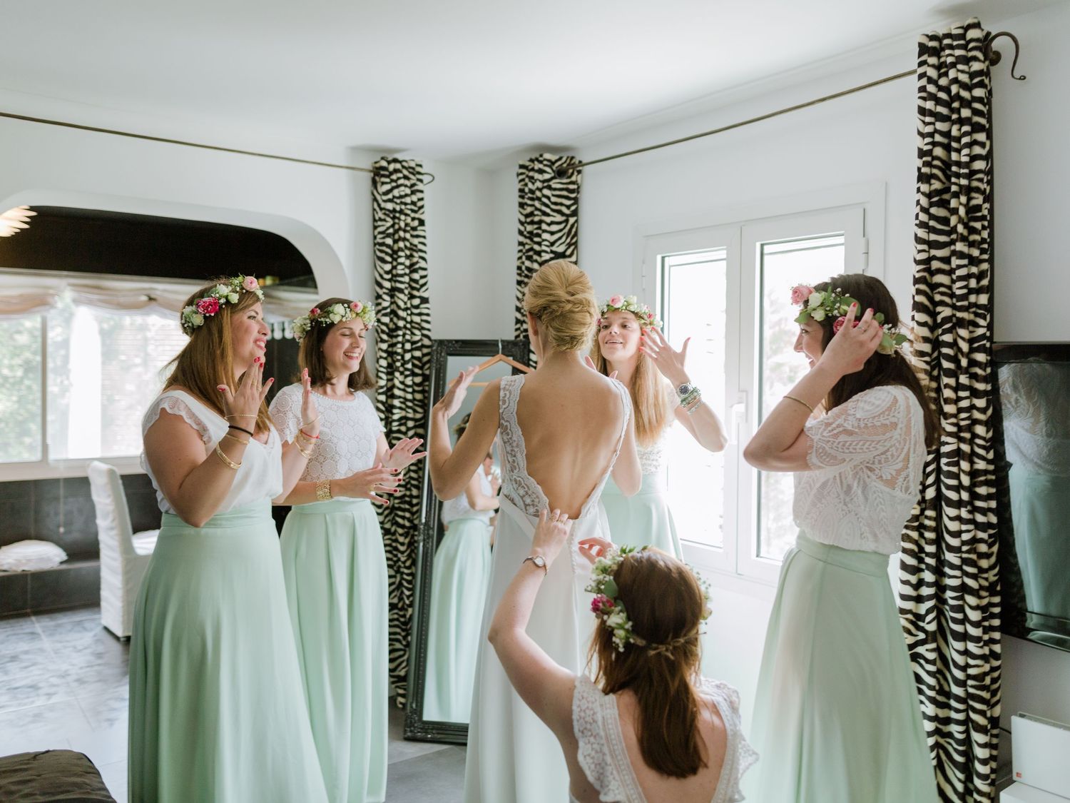 Dans une pièce élégante, les demoiselles d'honneur, vêtues de robes vert menthe et coiffées de couronnes de fleurs