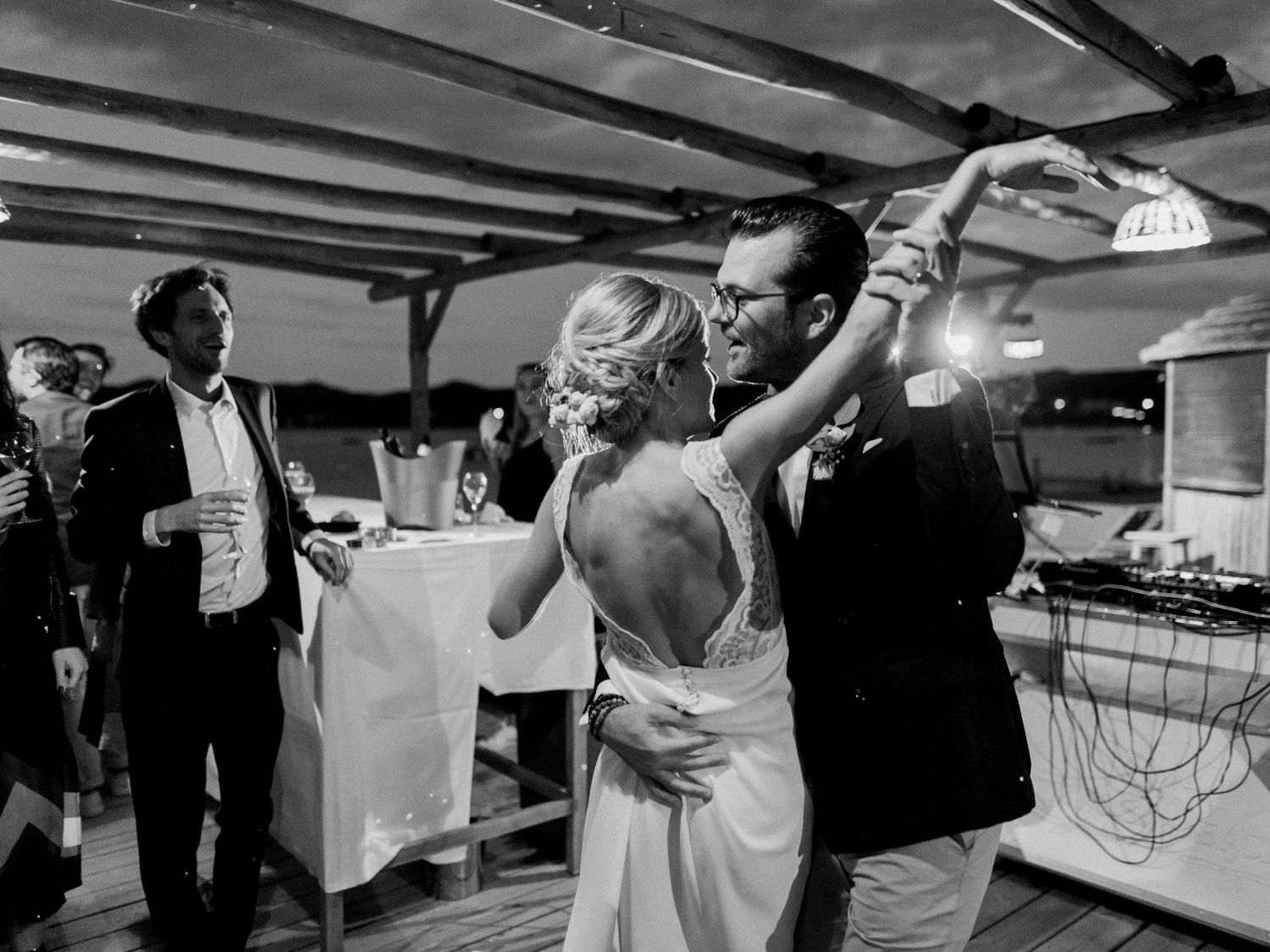 Photo en noir et blanc d'une mariée et d'un marié partageant leur première danse lors d'une réception de mariage.