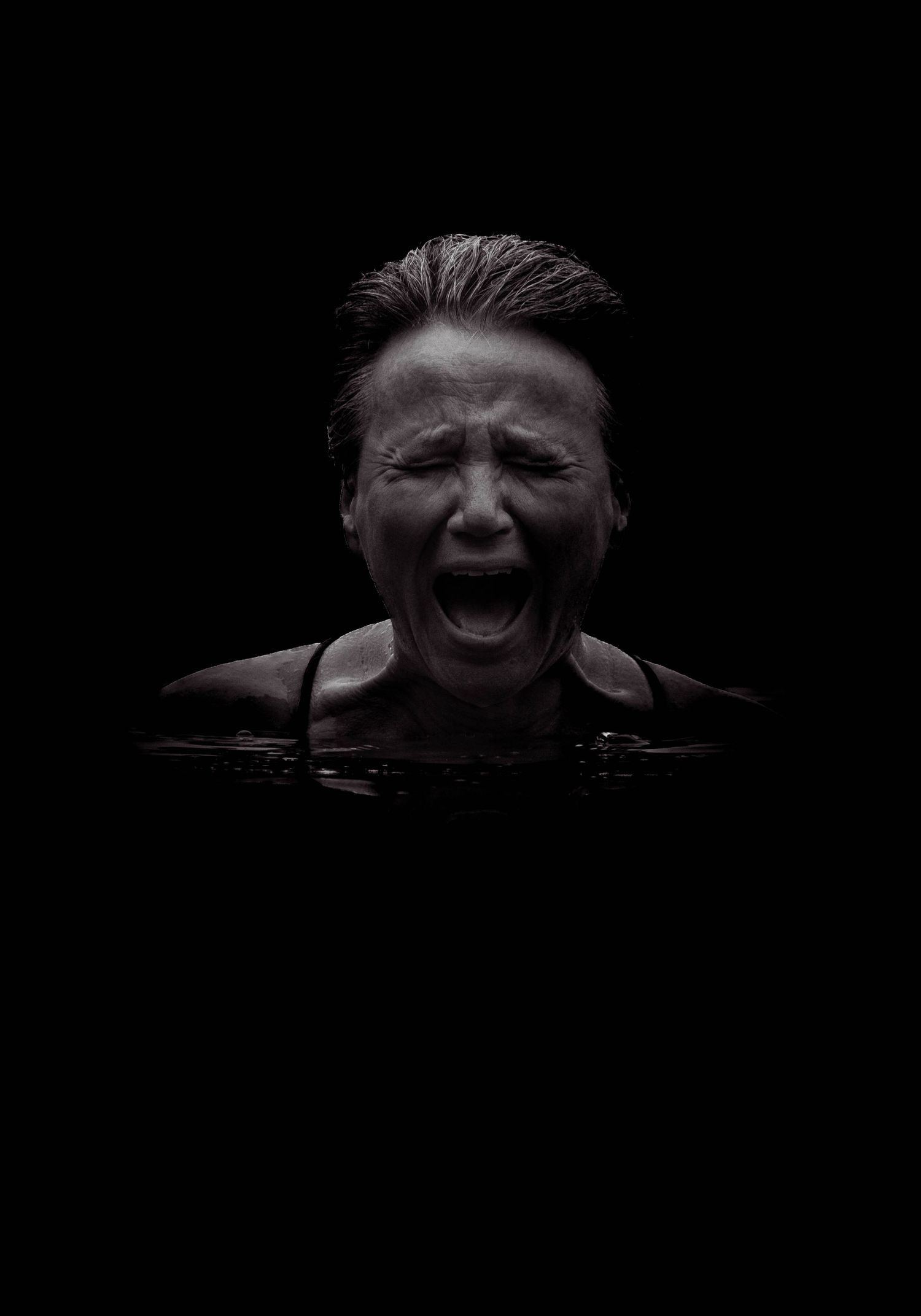 Une personne émergeant des eaux sombres en hurlant de douleur, immortalisée par une photographie en noir et blanc saisissante.