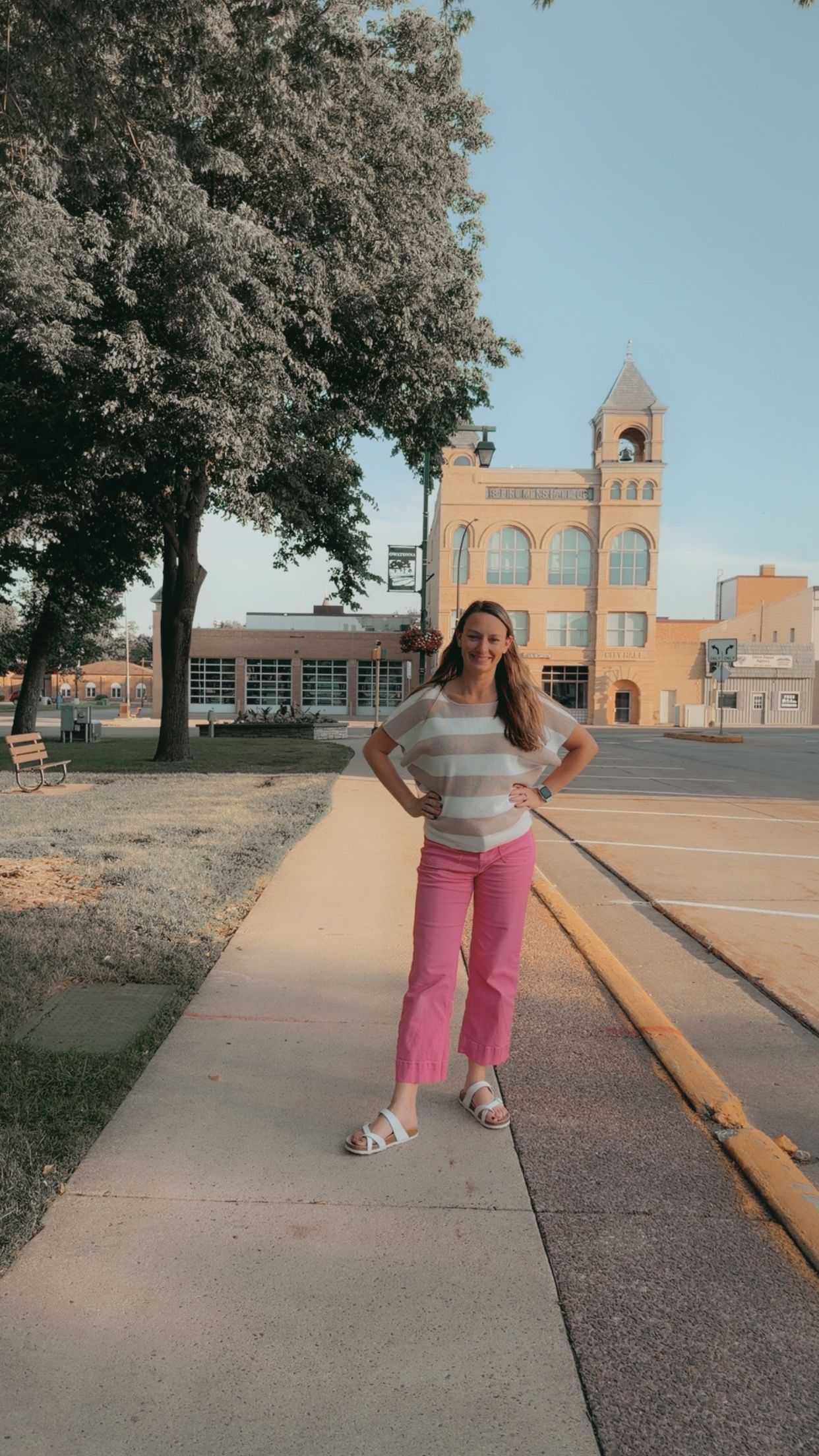Morgan standing on a sunny sidewalk in Southern Minnesota, representing her branding, creative direction, and support services for small bus