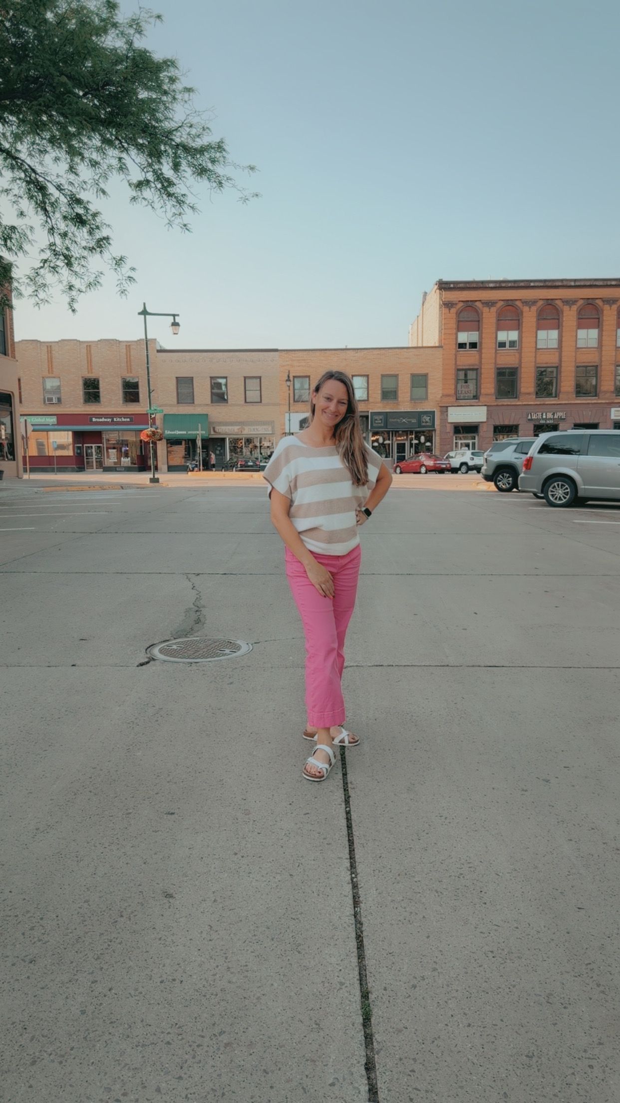 Morgan standing in a small Southern Minnesota downtown area, representing creative branding and design services for local small businesses.