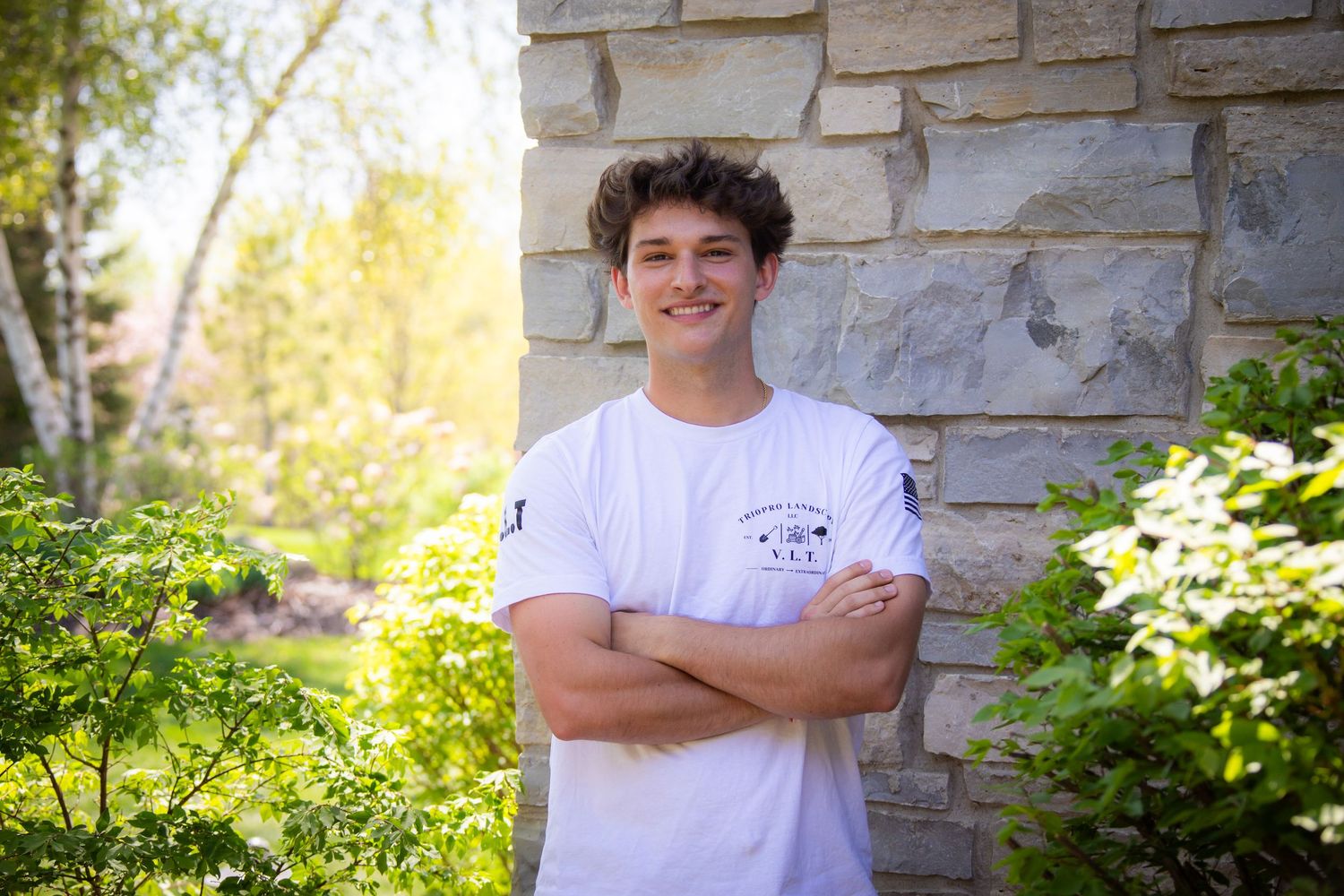 TRIO Landscaping team member standing outdoors near stone and greenery during a brand photography session with Silver Lining Marketing.