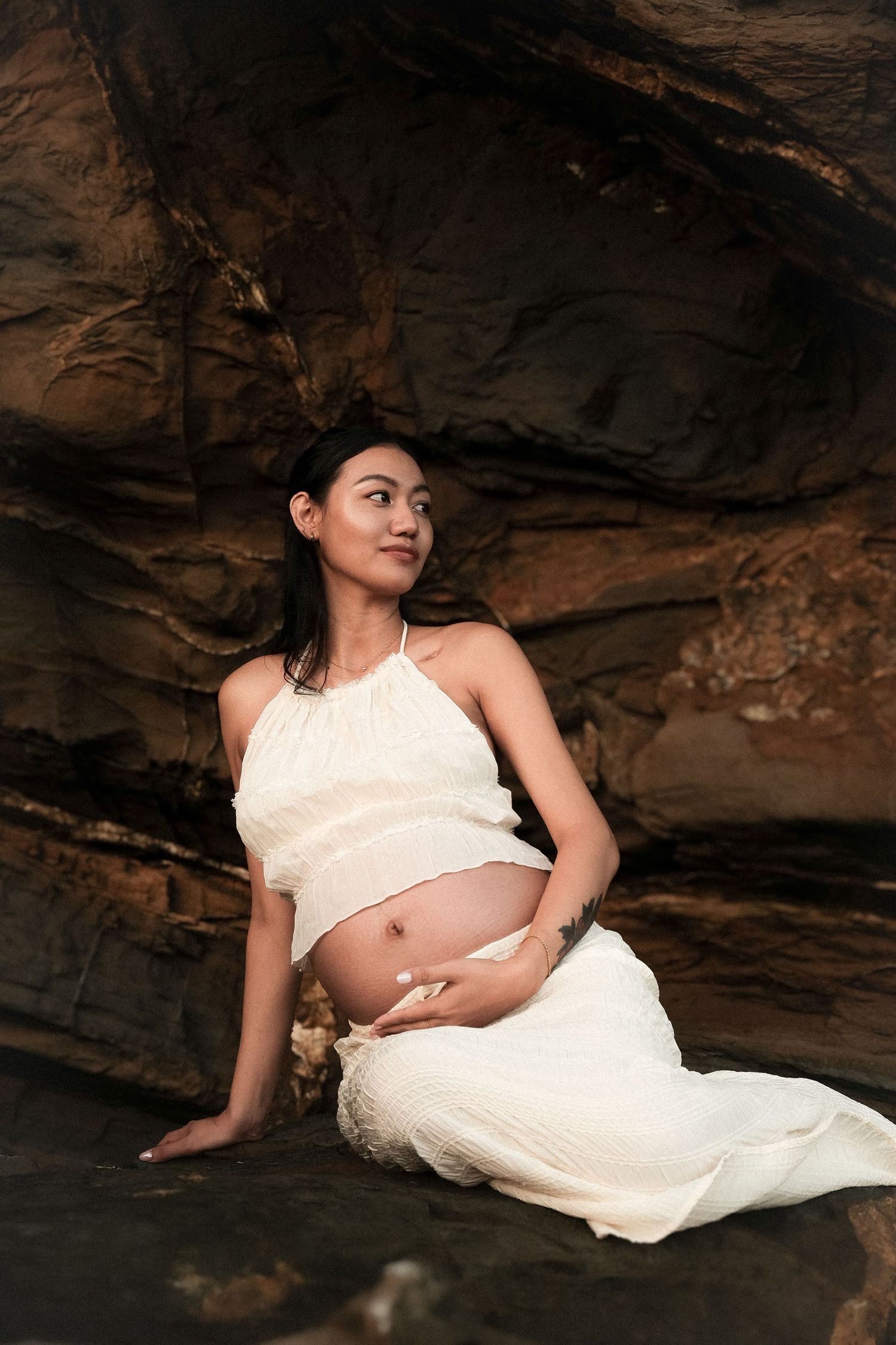 Portrait artistique de grossesse dans les rochers – séance photo future maman en Nouvelle-Calédonie par Solène Photographie