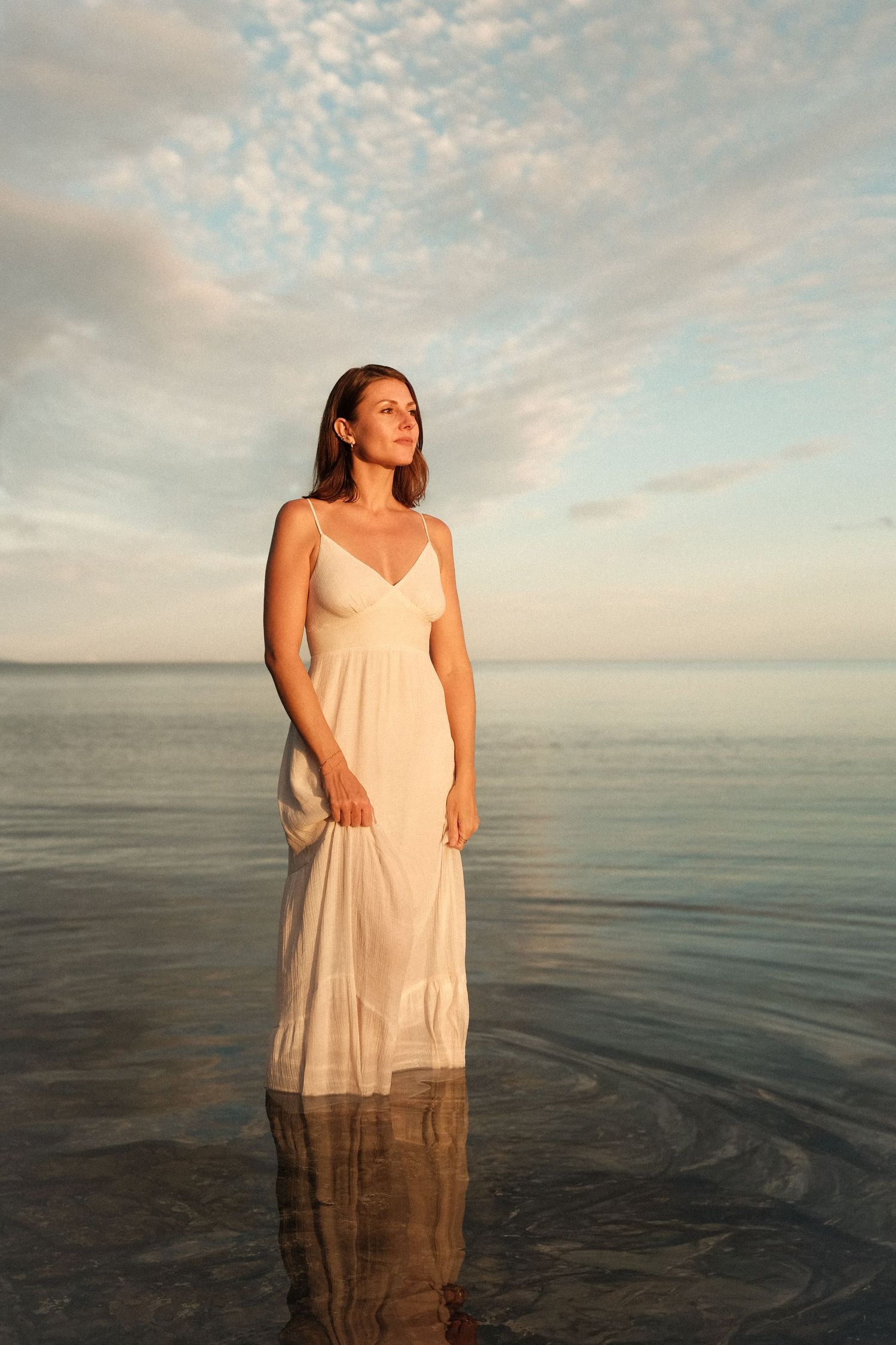 Femme en robe blanche elegante douce dans le lagon au coucher de soleil – photographe portrait Nouvelle-Calédonie Solène Photographie
