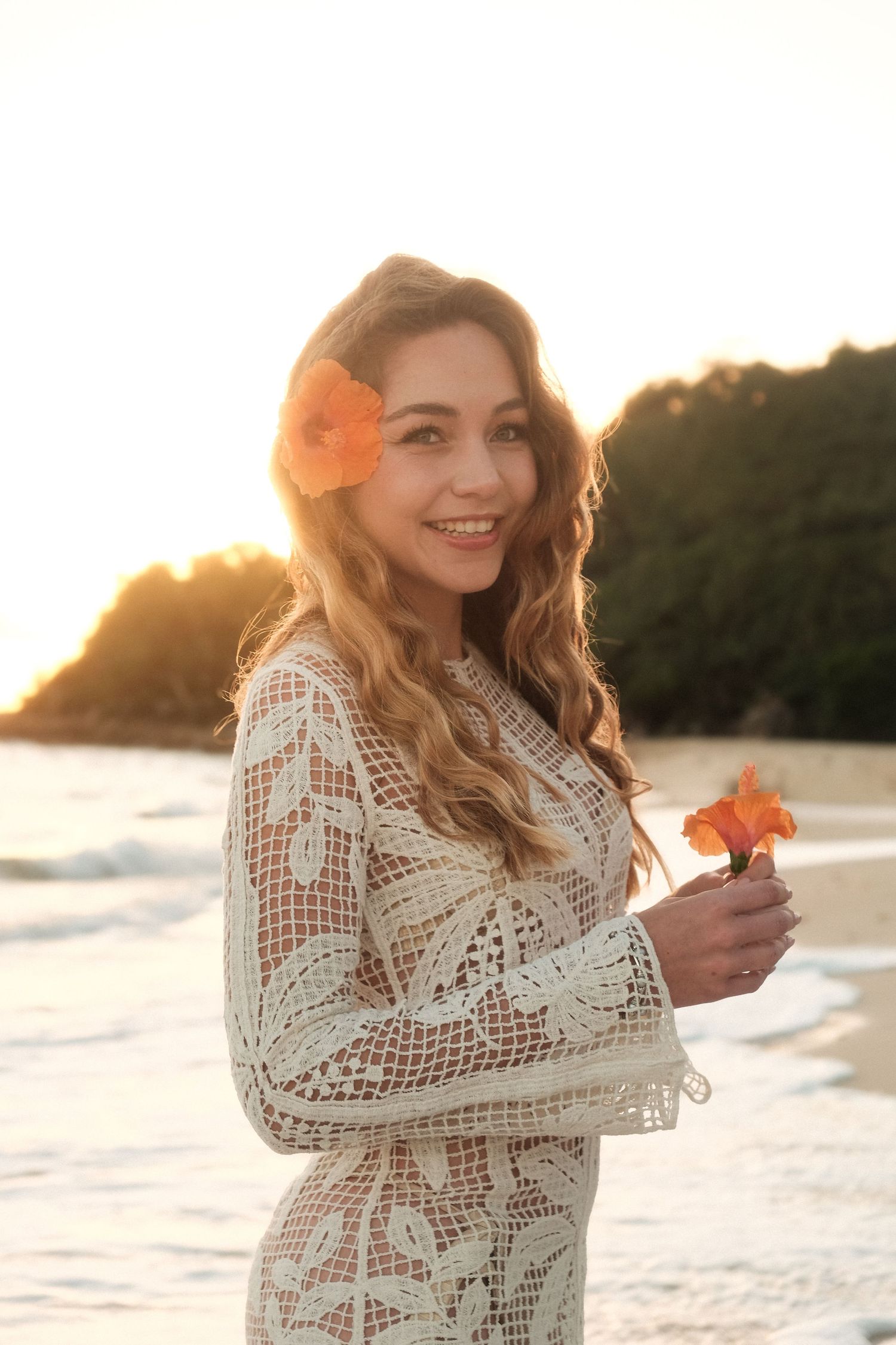 Jeune femme sur la plage au coucher de soleil  avec une fleur– séance solo par Solène Photographie  en Nouvelle-Calédonie (NC)