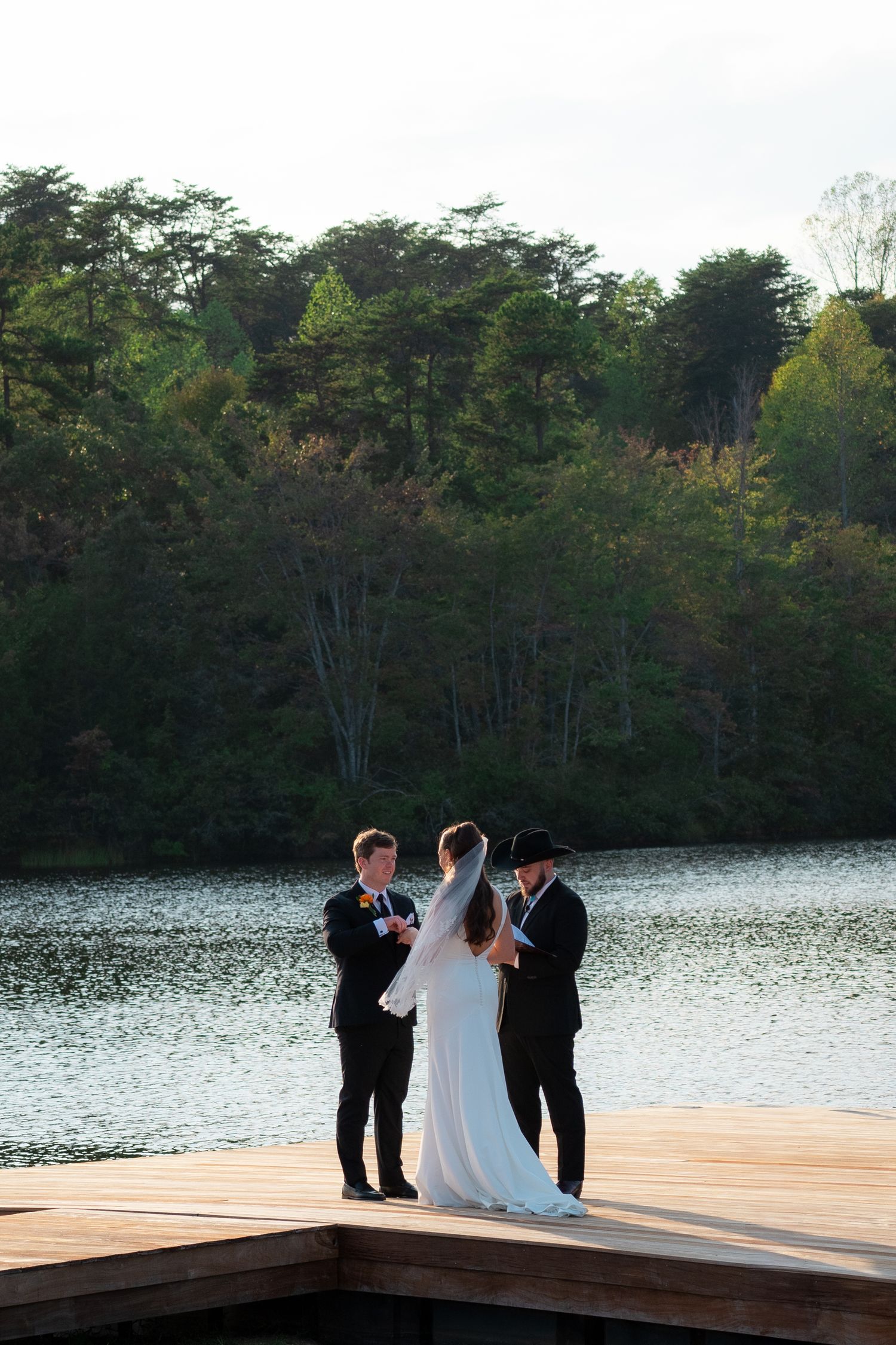 Wedding ceremony of a man and woman on a lake with green scenery in Scottsville, Virginia.