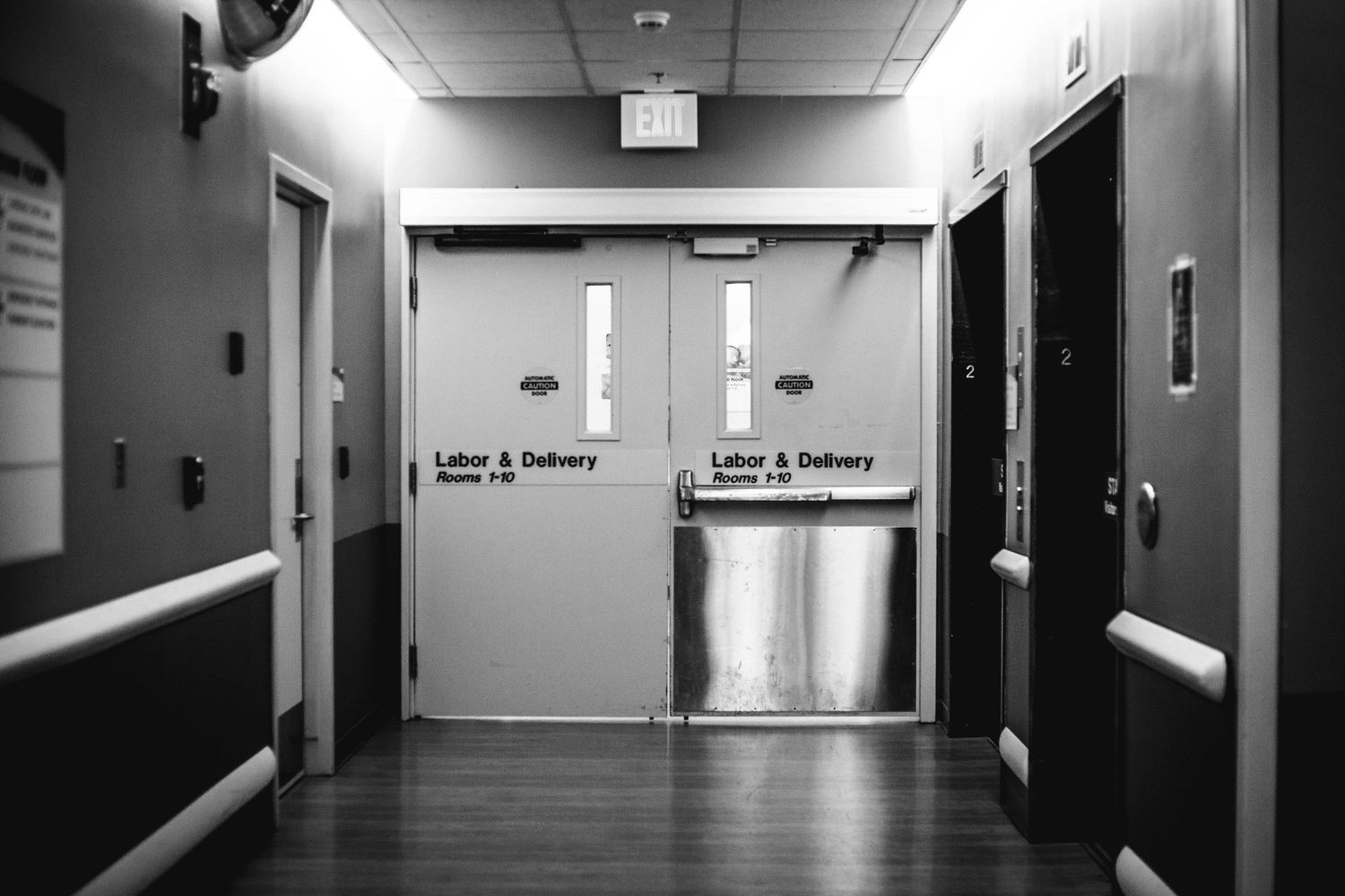 Black and white photo of Labor and Delivery double doors in hospital hallway.