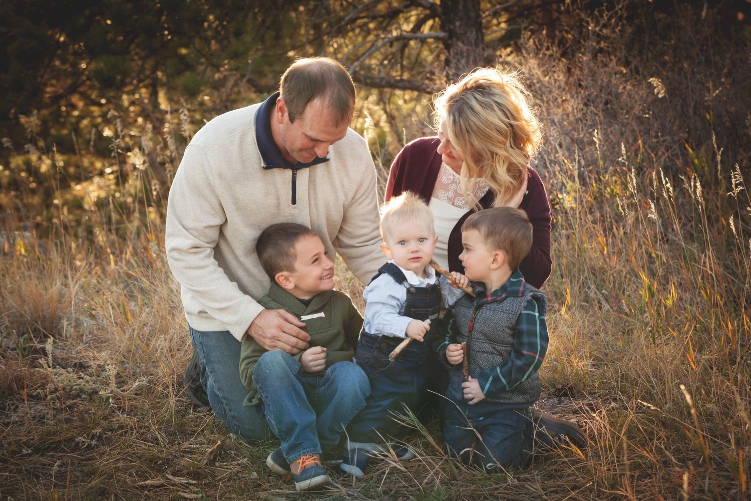 A casual family portrait series set in golden autumn grass showing tender moments and playful interactions during sunset.